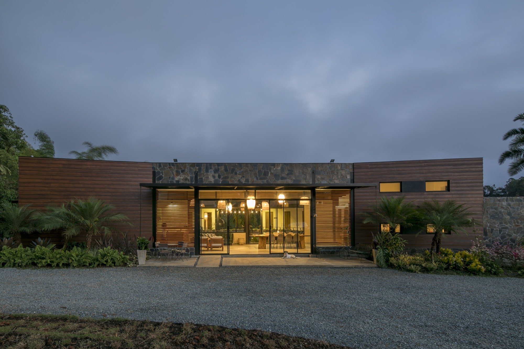 Araucana Lodge surrounded by palms and gardens at dusk.