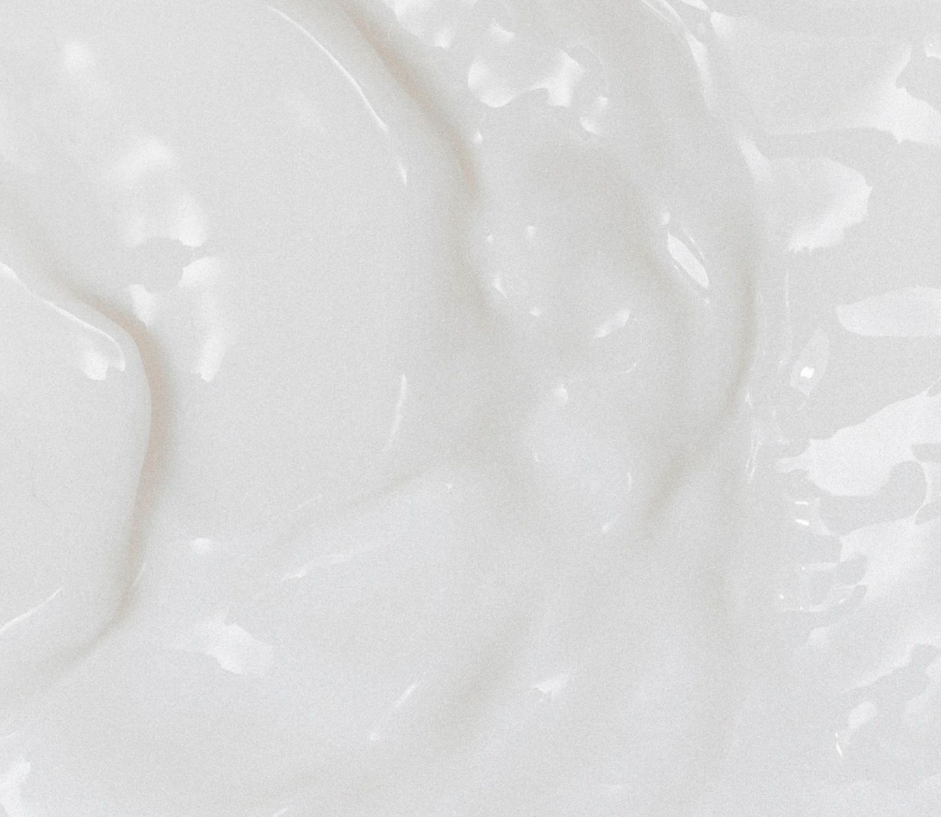Close-up of a creamy, white, frozen dessert with visible soft serve textures.