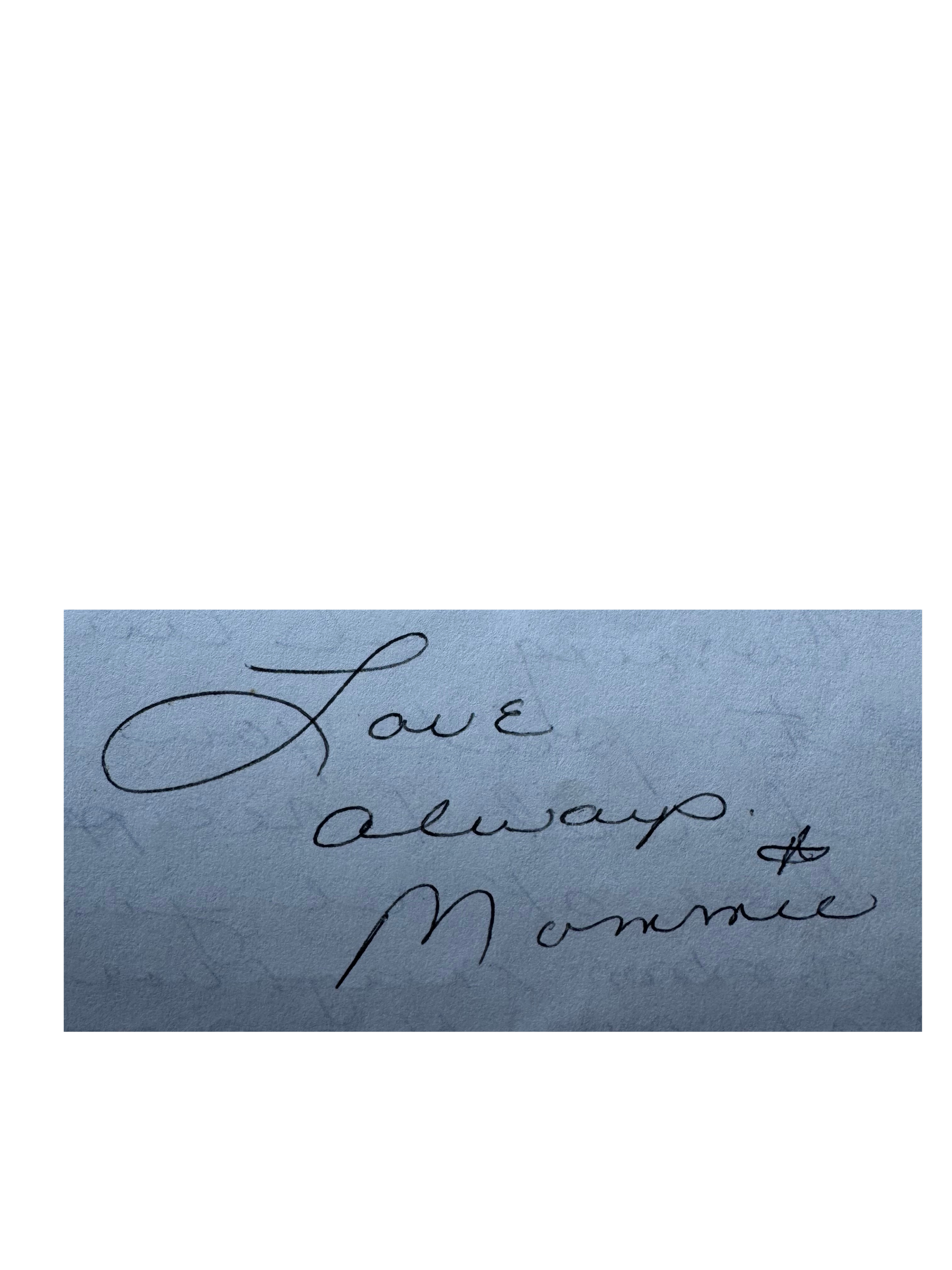 Close-up of handwritten note with Latin words 'Love' and 'Amor' written in cursive on light blue paper.