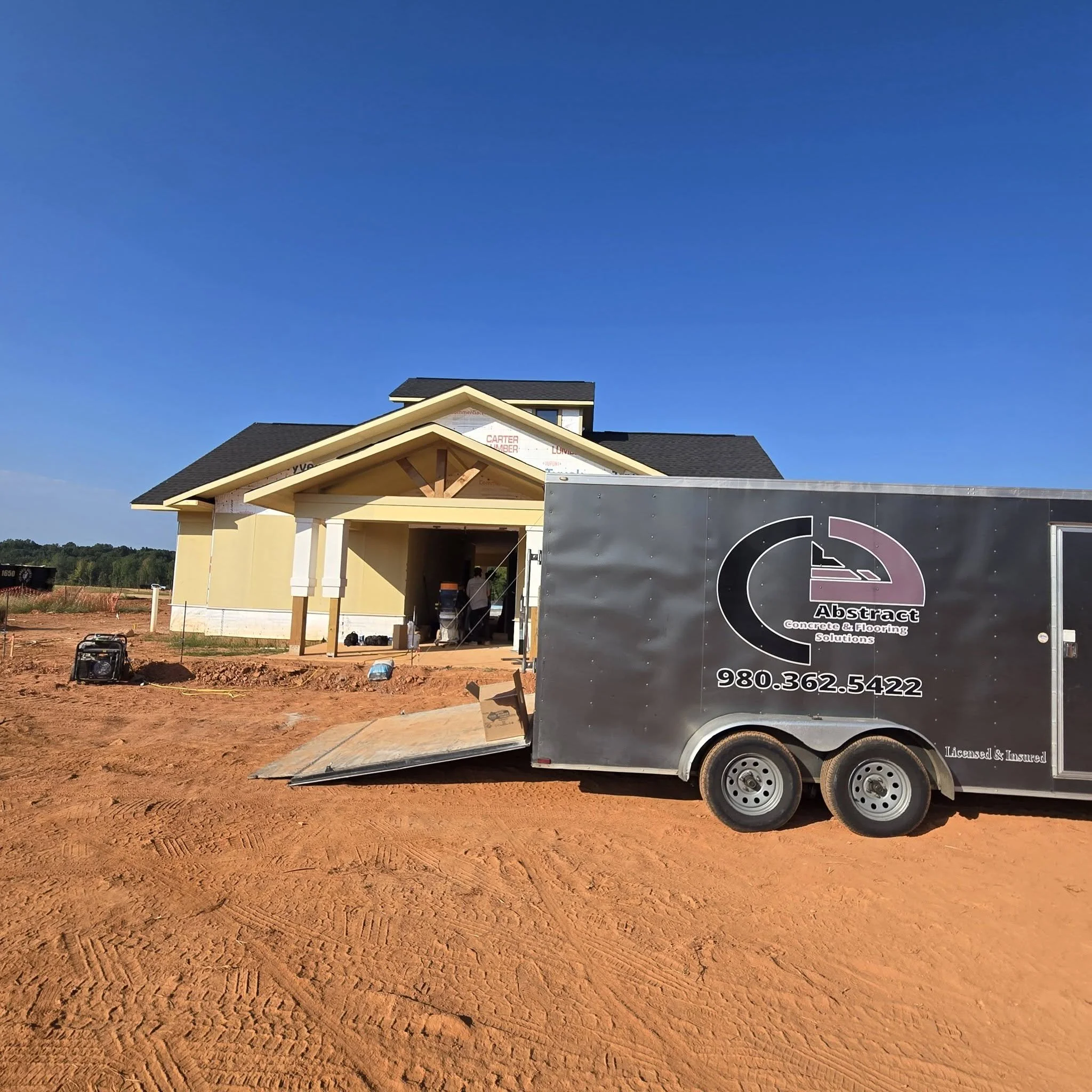 trailer with a sign reading 'Abstract Concrete & Flooring Solutions' is in the foreground.