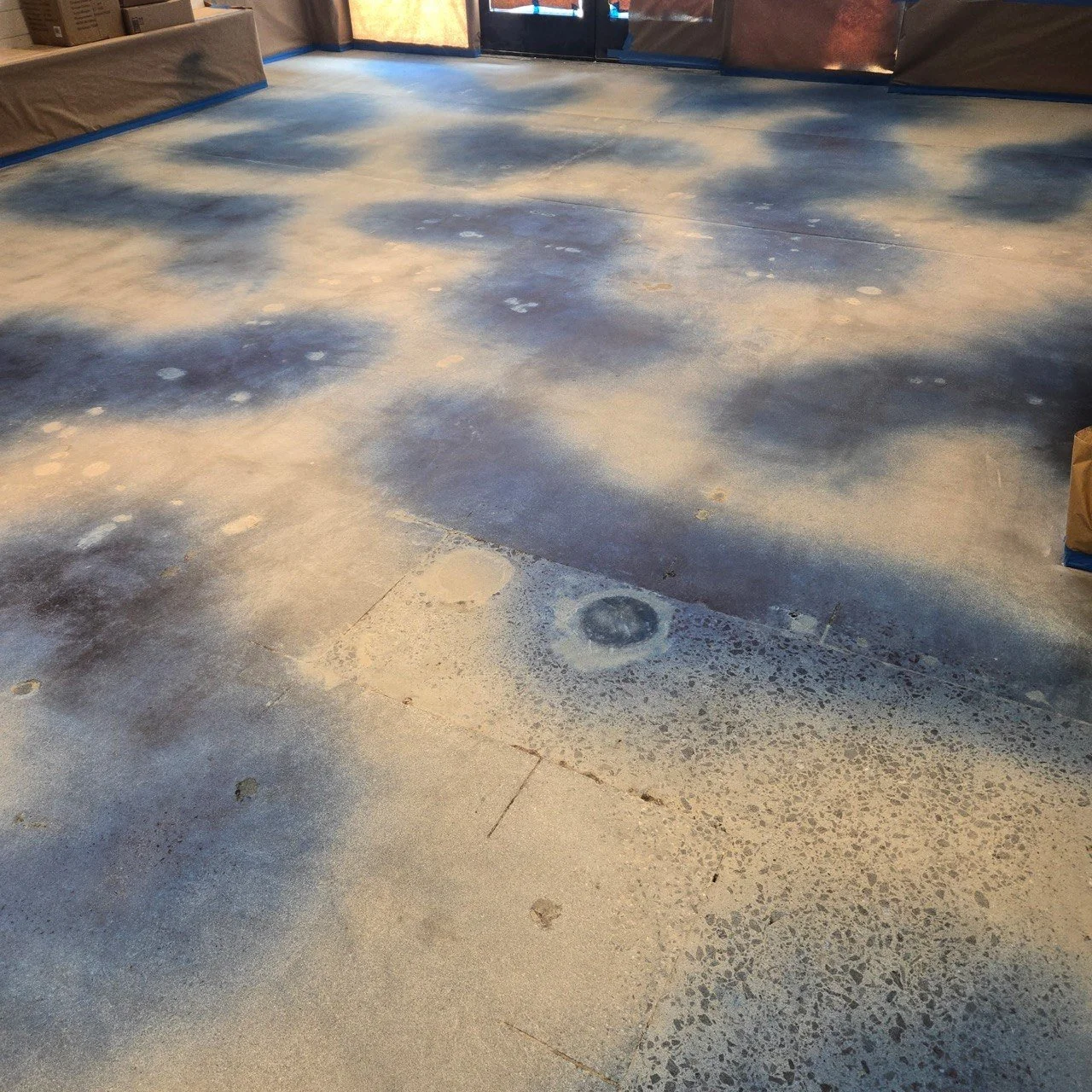 Interior of a room with a concrete floor that has been sanded, showing a concrete stain
