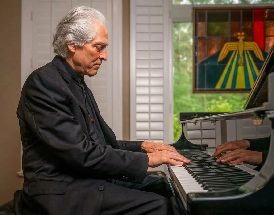 David Masterson in a black suit playing a grand piano indoors