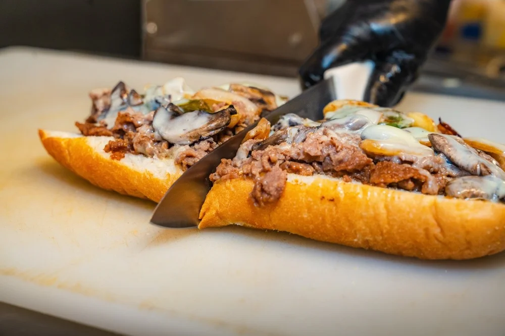 Bottoms Up cheesesteak with melted cheese on an Amoroso roll