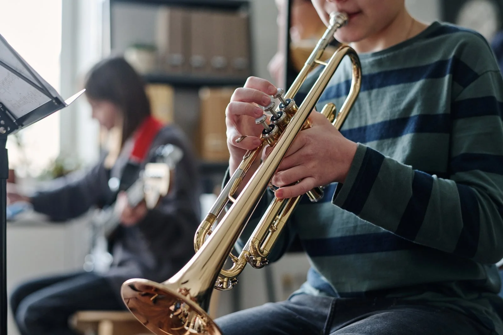 A pupil playing the trumpet in a music lesson