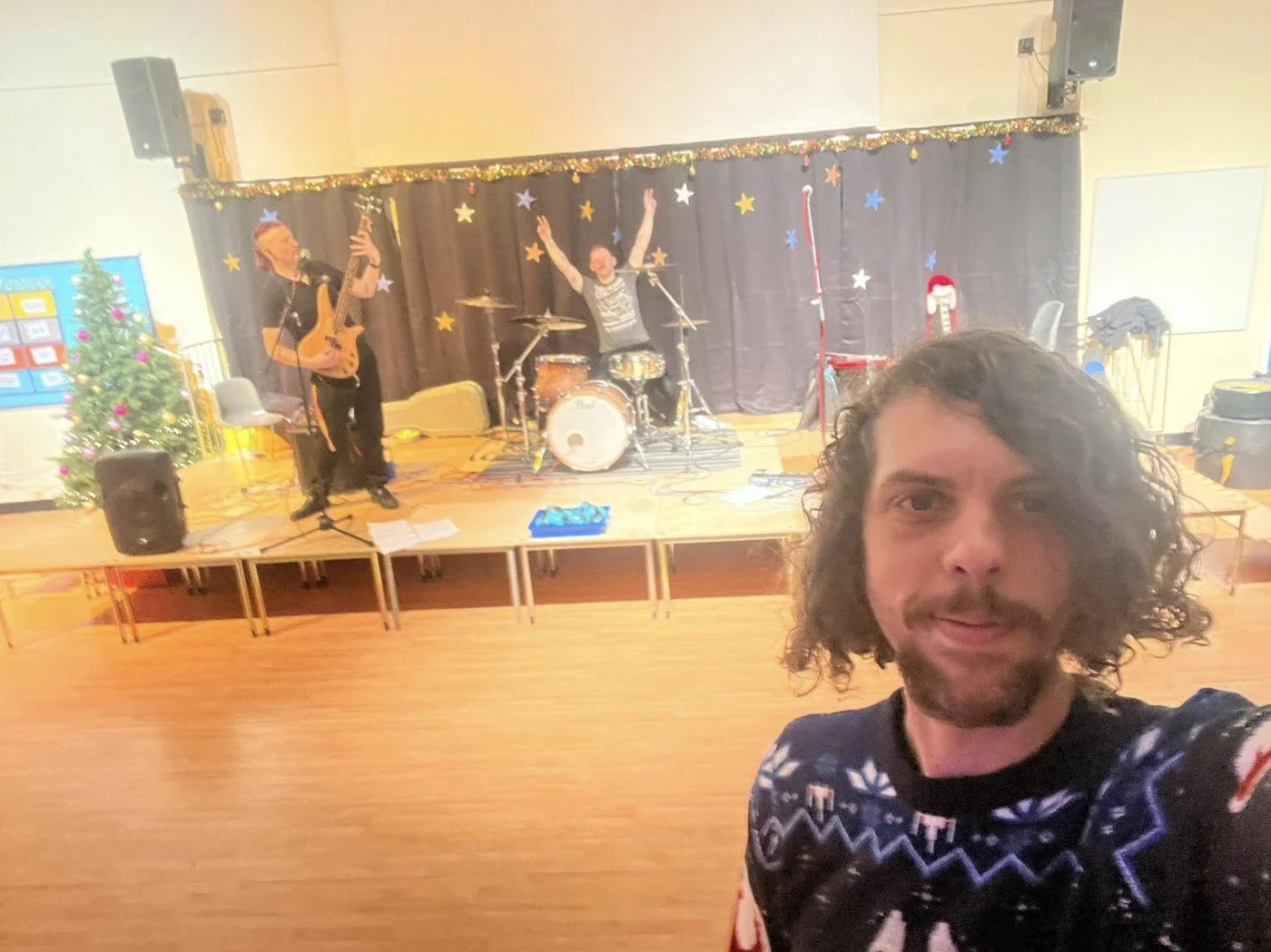 The Akademiks set up on stage in a school hall decorated for Christmas