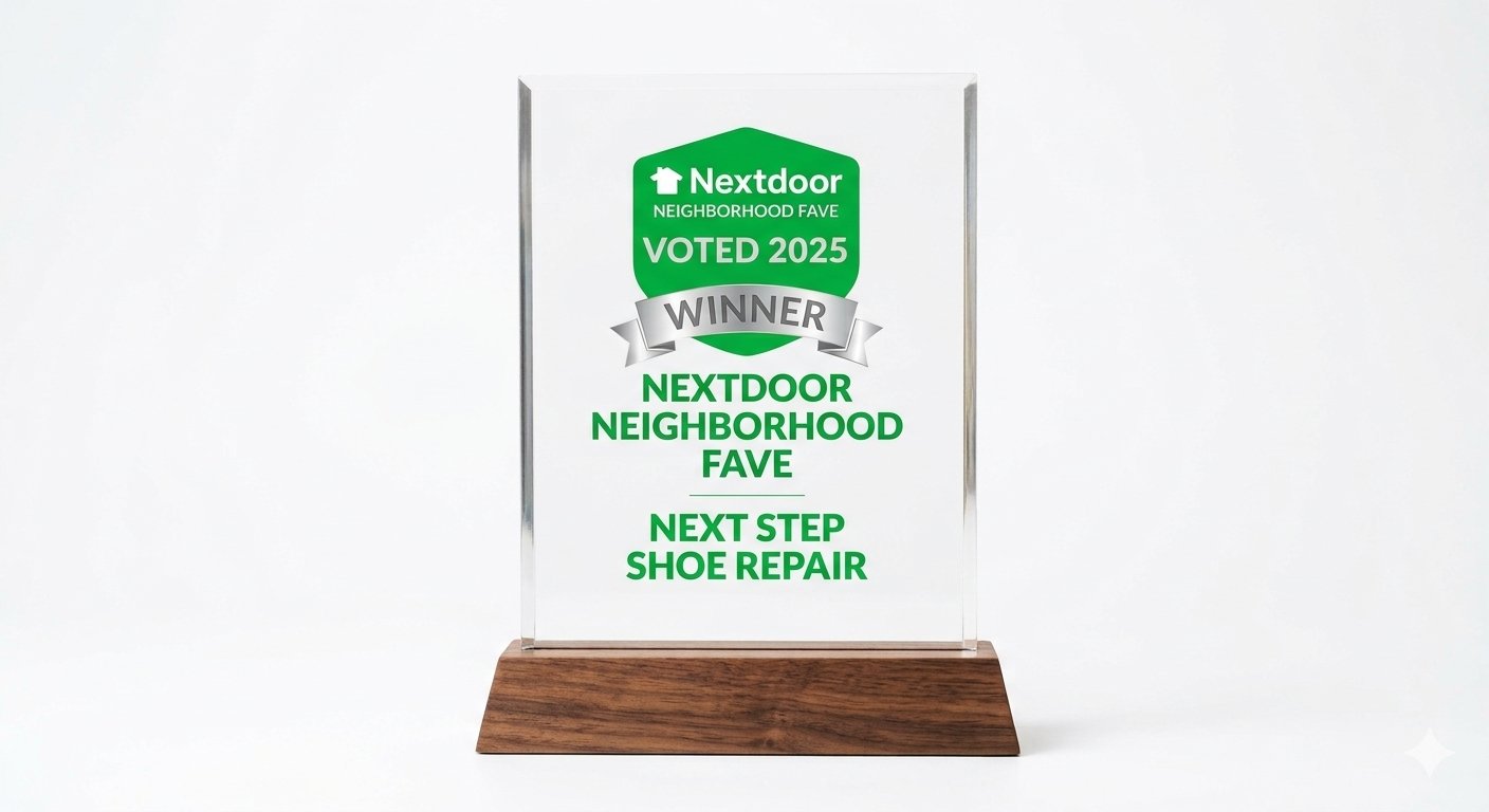 A clear acrylic award plaque with a wooden base, featuring a green and silver design and text recognizing 'Nextdoor Neighborhood Fave, Voted 2025, Winner' for 'Next Step Shoe Repair'.