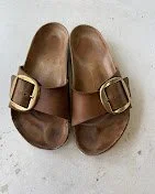 Pair of brown leather clogs with buckles