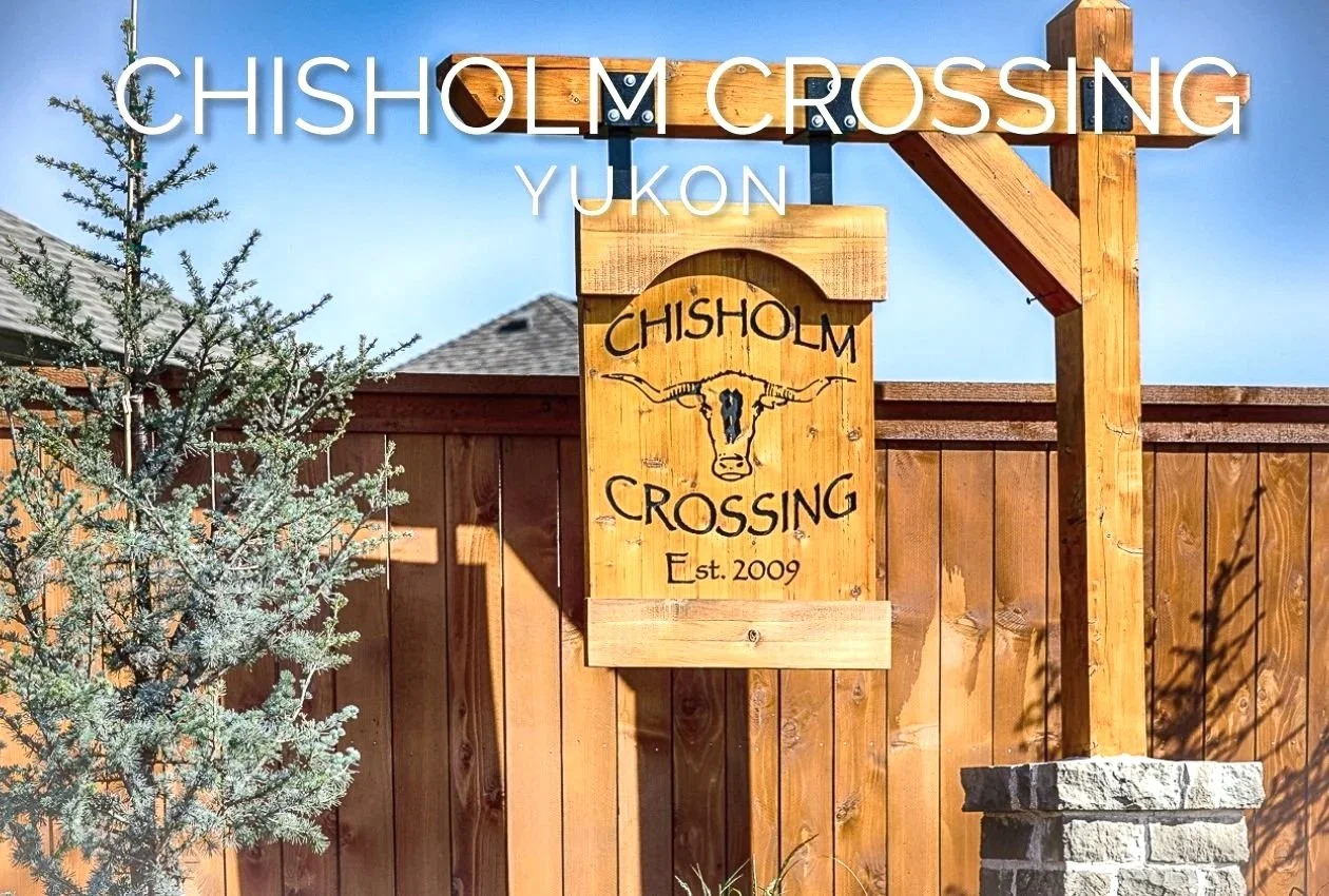 Chisholm Crossing neighborhood entrance sign in Yukon, Oklahoma, with rustic wood detailing and a cattle skull design.