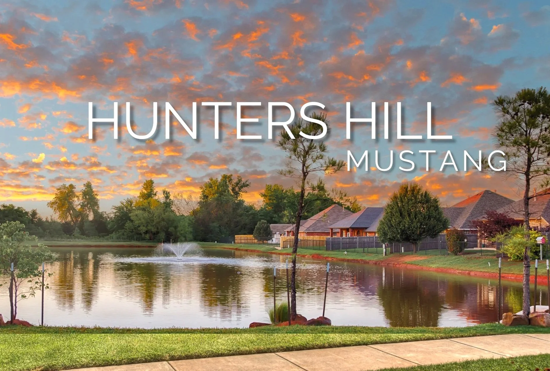 Hunters Hill neighborhood in Mustang, Oklahoma, with a landscaped pond, fountain, mature trees, and homes in the background at sunset.