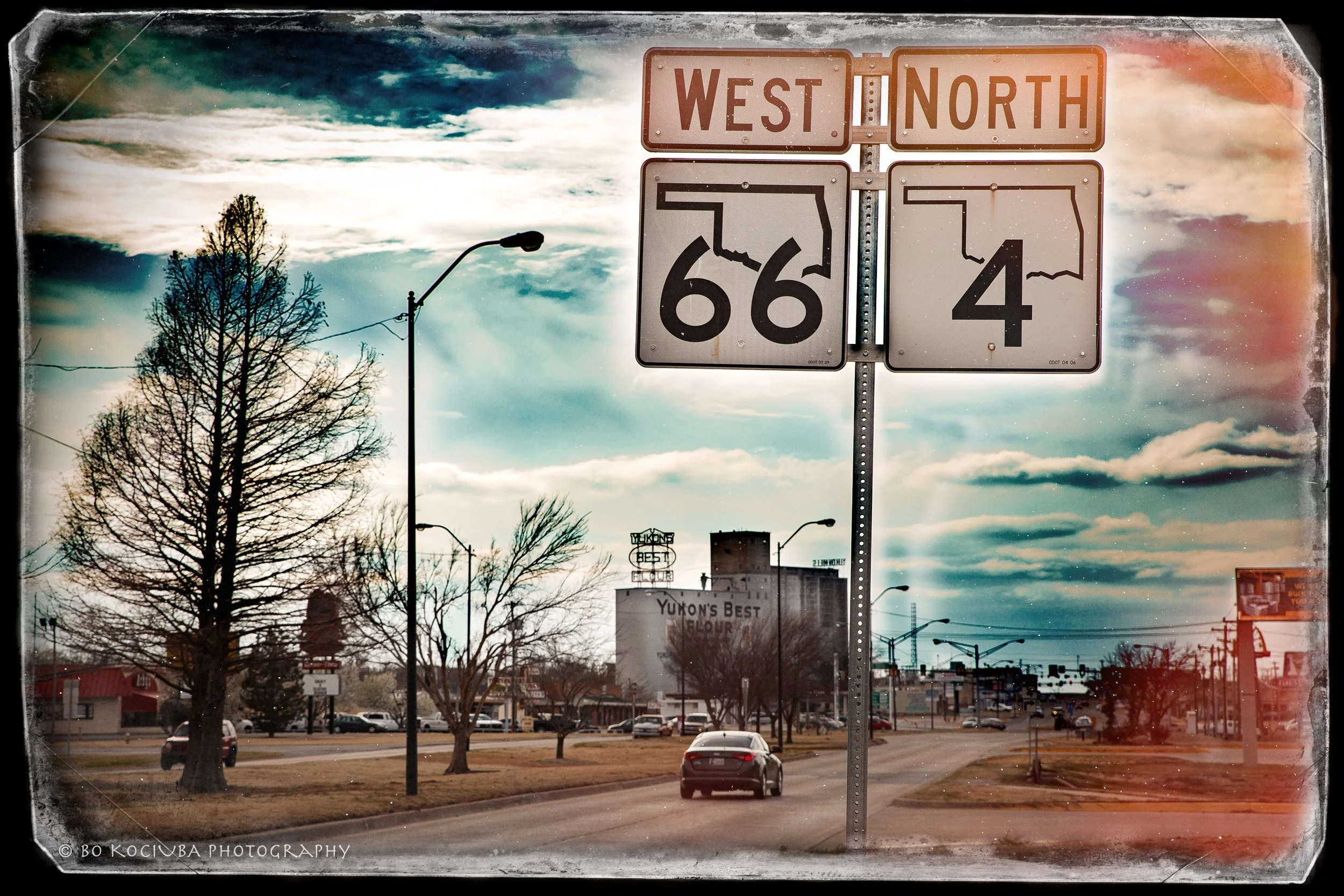 Historic Route 66 West and Oklahoma Highway 4 North road signs at an intersection in Yukon, Oklahoma.