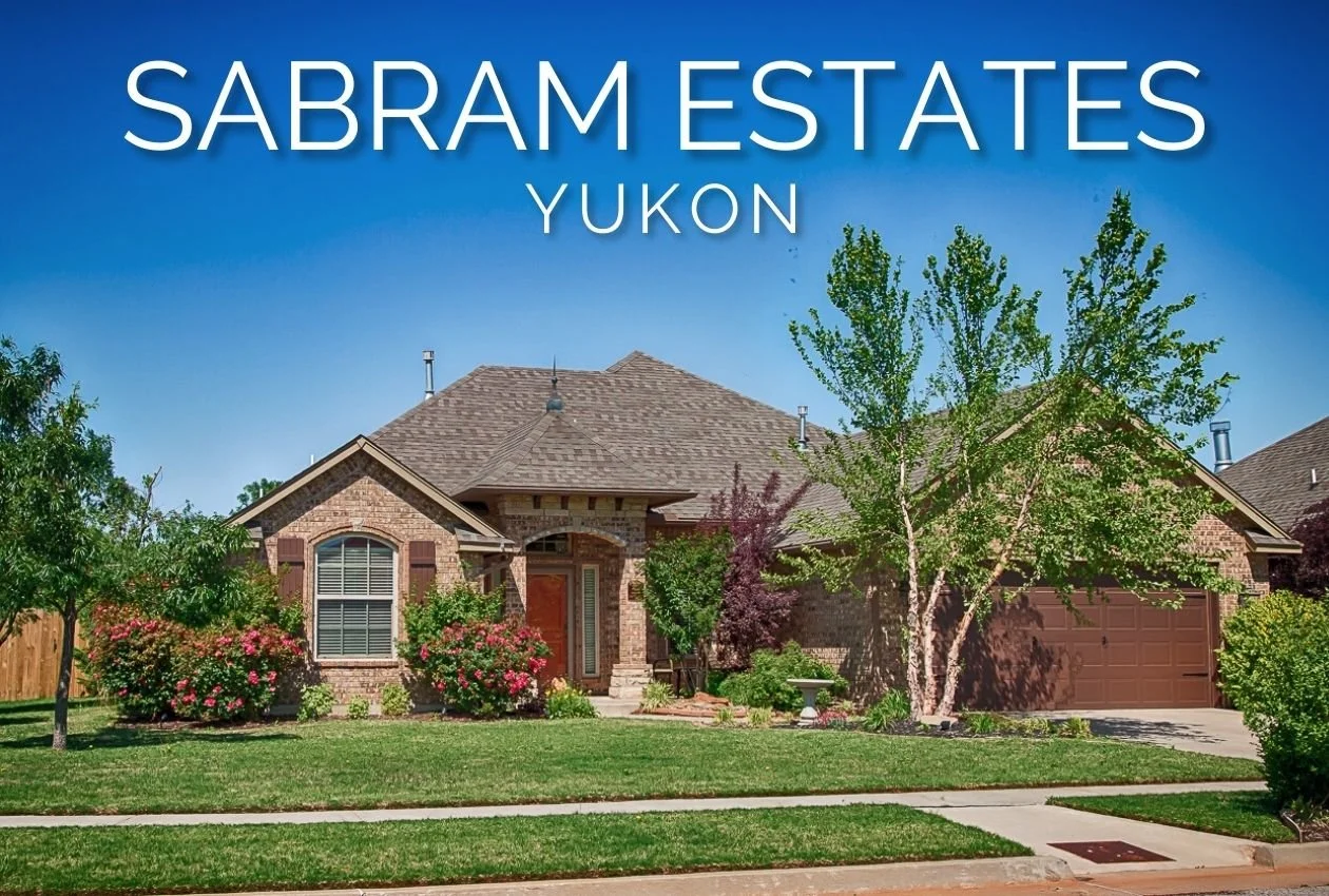 Brick home in Sabram Estates near Lake Overholser in Yukon, Oklahoma, with mature trees, landscaped front yard, and a sidewalk.
