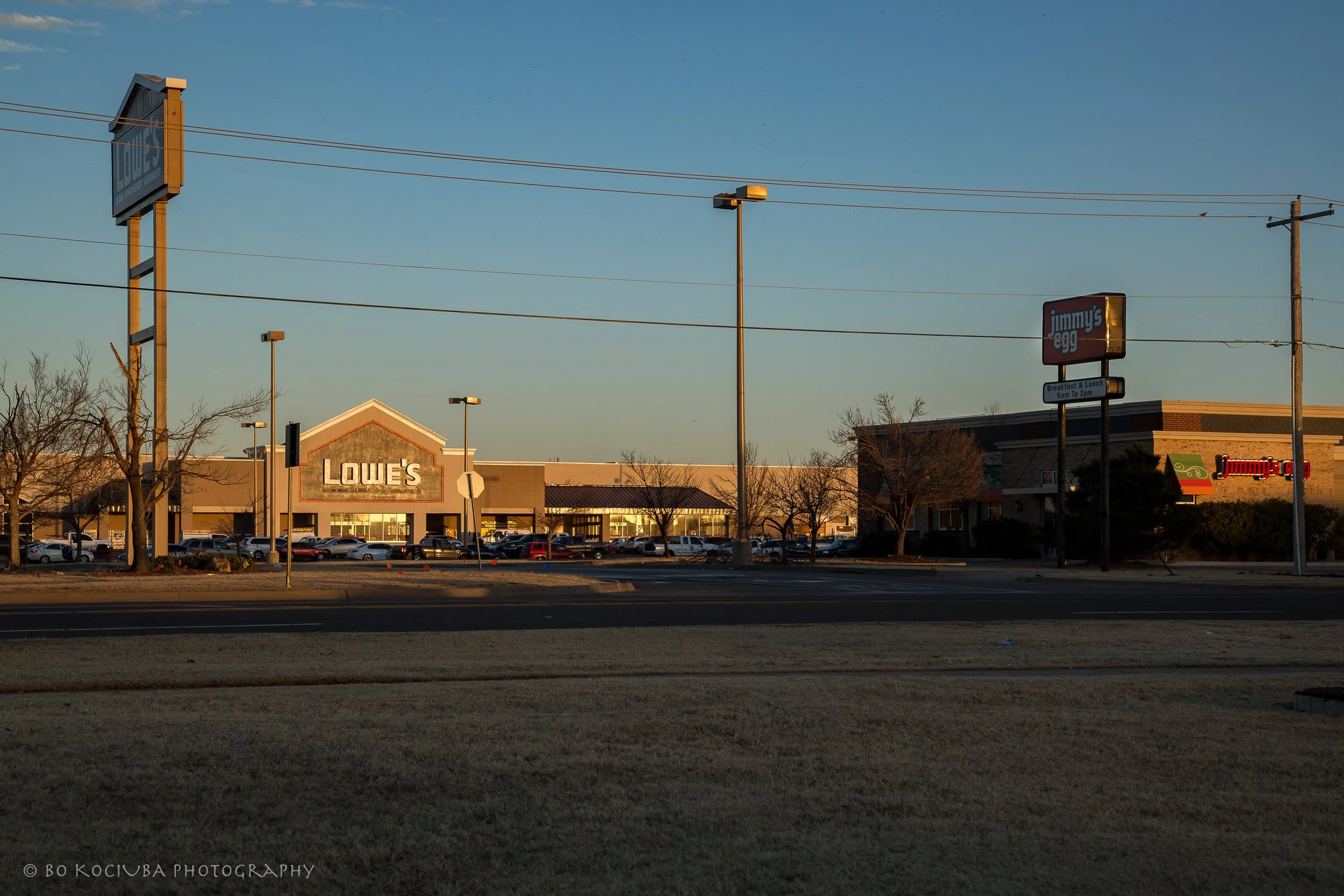 Shopping area along Garth Brooks Boulevard in Yukon, Oklahoma, featuring Lowe's and Jimmy's Egg in the late afternoon light.