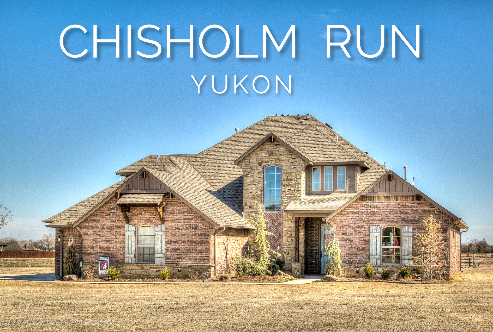 Two-story brick and stone home in Chisholm Run, a Yukon-area Oklahoma neighborhood known for spacious residential lots.