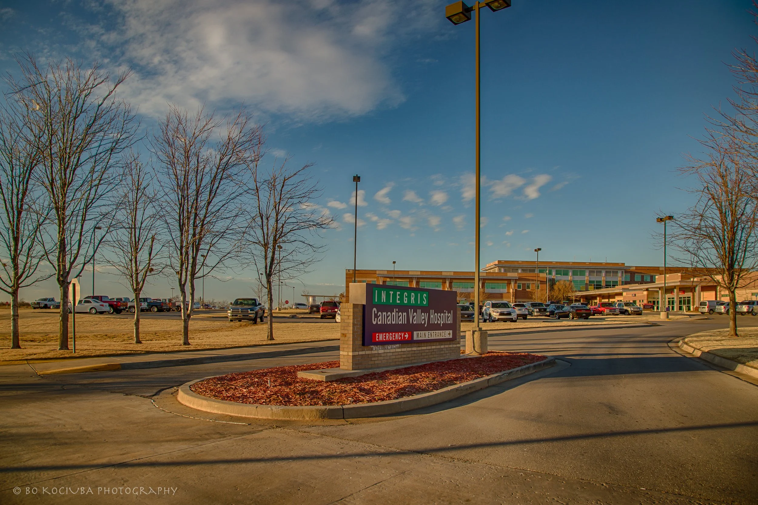 INTEGRIS Canadian Valley Hospital in Yukon, Oklahoma, with directional signs for the main entrance and emergency department near Garth Brooks Boulevard.