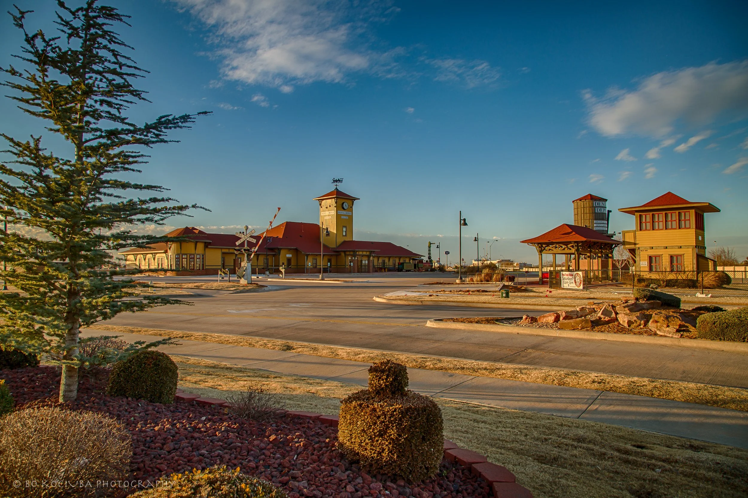 Dental Depot building along Garth Brooks Boulevard in Yukon, Oklahoma, featuring its distinctive brick tower with a clock, landscaped grounds, and parking area.