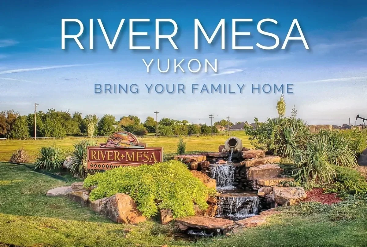 River Mesa neighborhood entrance in Yukon, Oklahoma, featuring landscaped stonework, a small waterfall, and seasonal plantings.