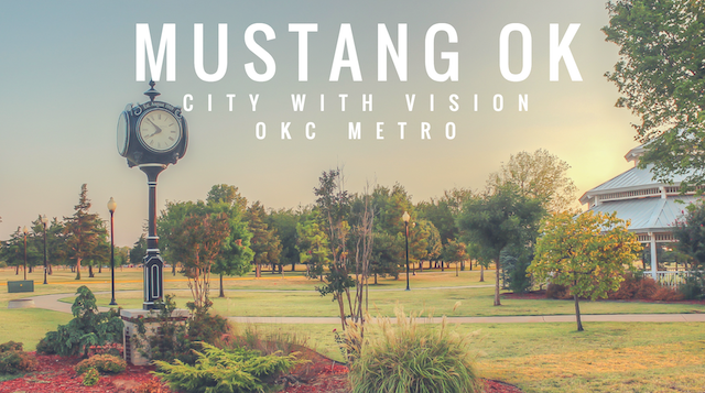 Landscaped park in Mustang, Oklahoma, featuring a decorative street clock, pavilion, and trees at sunset, with the words “Mustang OK, City with Vision, OKC Metro.”