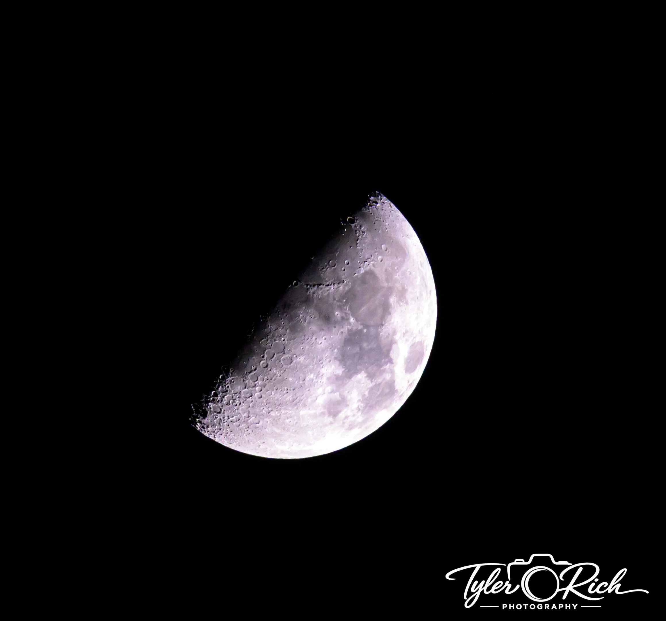 Close-up of the moon showing detailed craters against a black sky, with a signature at the bottom right corner reading 'Tyler R Rich Photography'.