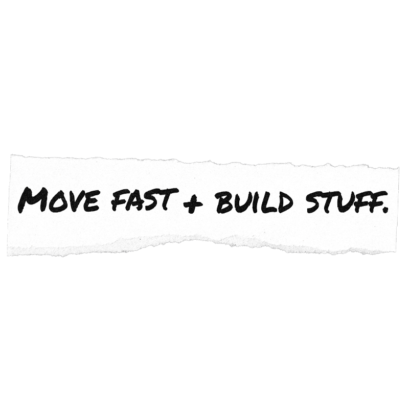 Handwritten black text reading “MOVE FAST + BUILD STUFF.” on a torn white paper strip