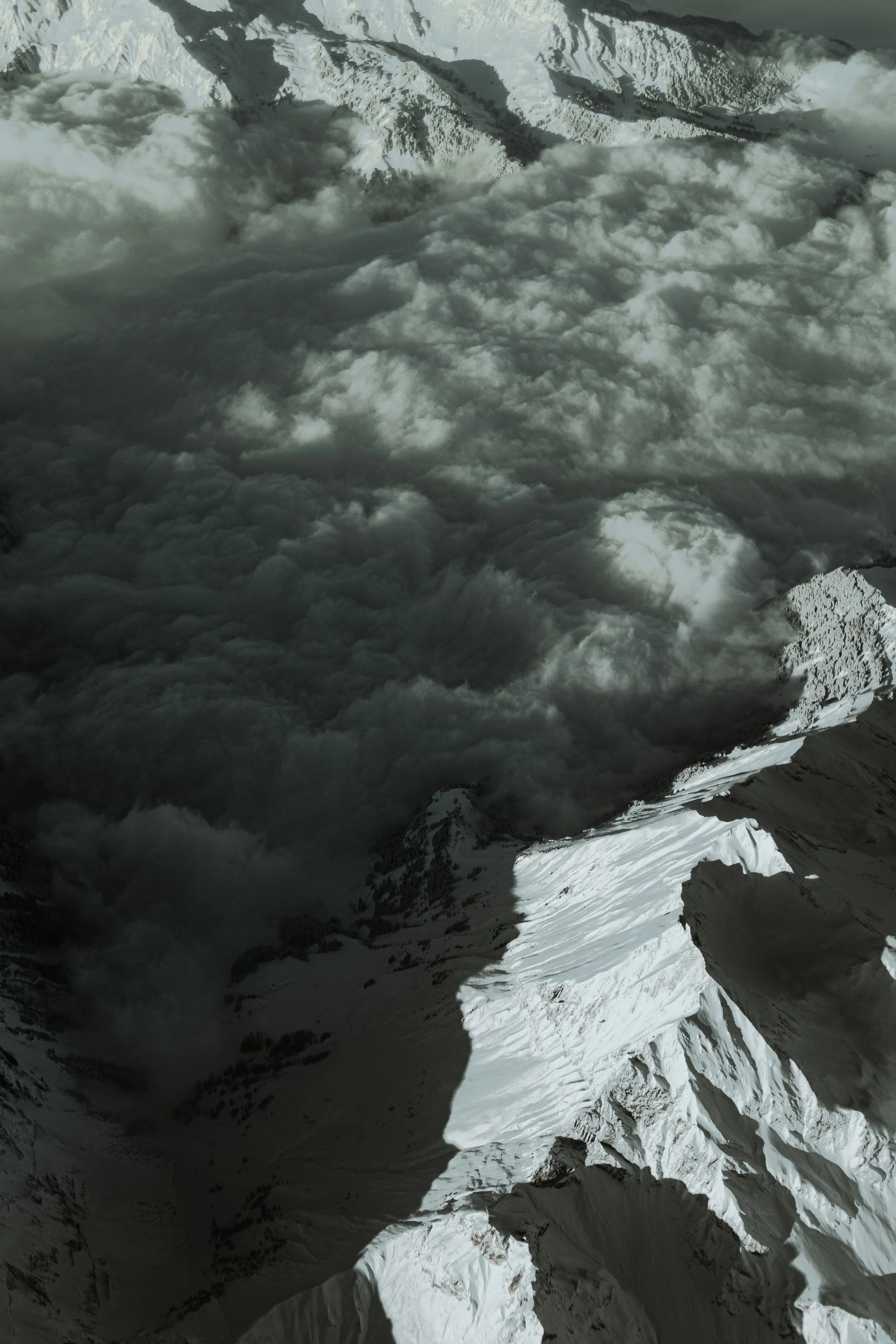 Snow-covered mountain peaks with clouds partially obscuring the view.