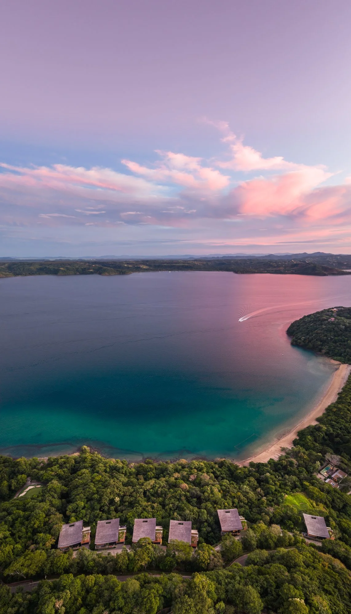 Aerial view of villas above a turquoise bay at sunset in Peninsula Papagayo, Guanacaste, Costa Rica