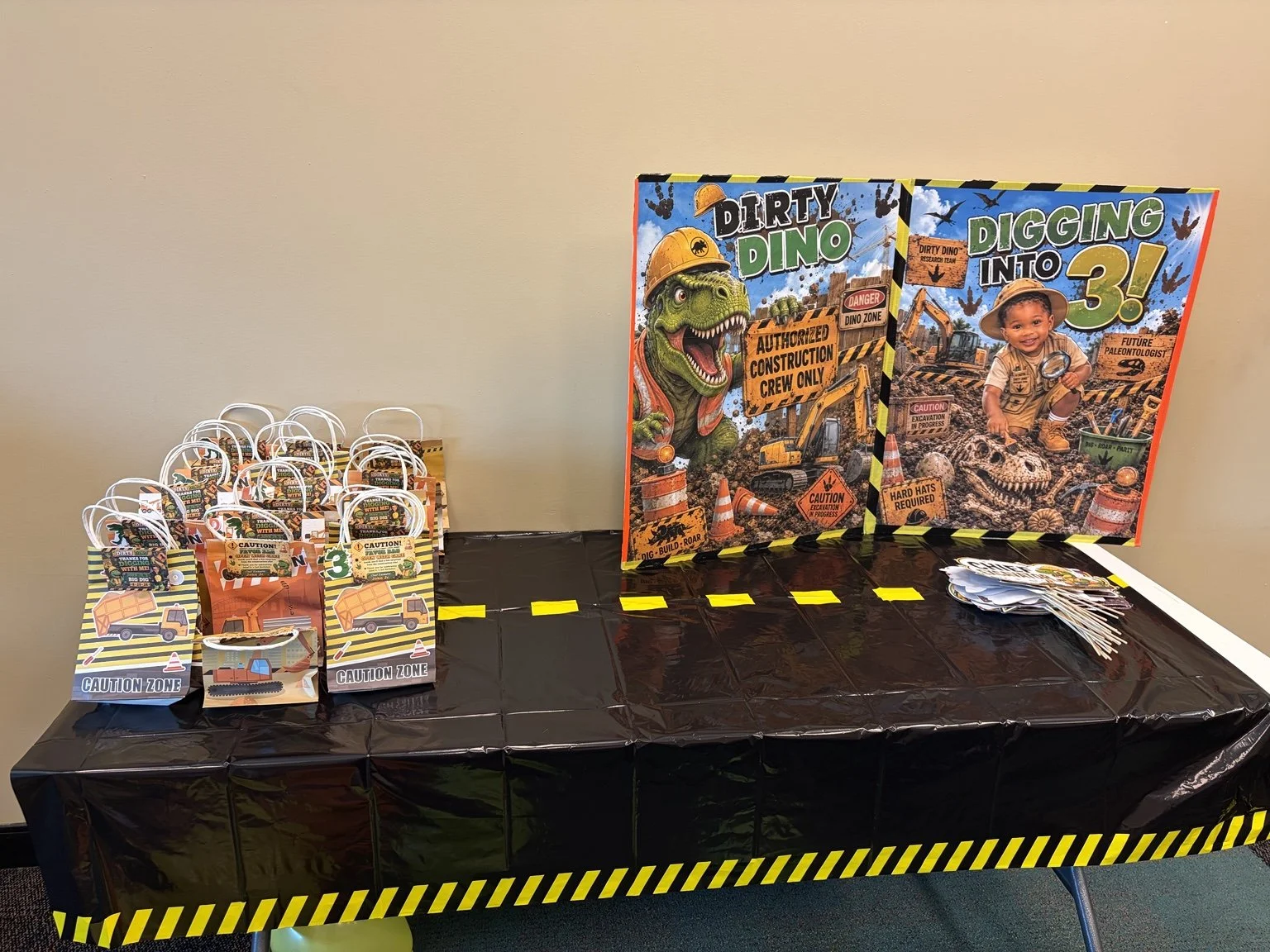 Dinosaur and construction-themed third birthday party display with custom favors, decorations, and activity materials.