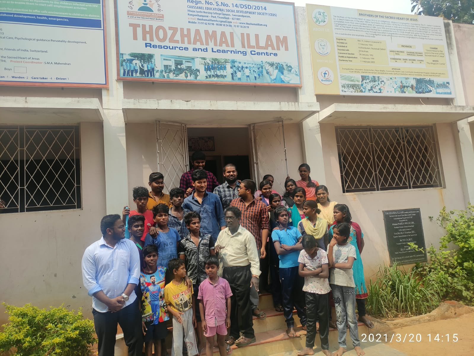 Children and adults standing outside Thozhamai Illam Resource and Learning Centre.
