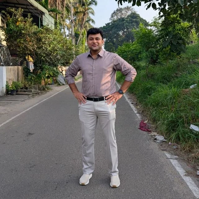 Man standing on a rural road surrounded by trees.