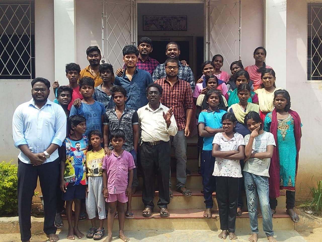 Children and adults standing together outside a building.