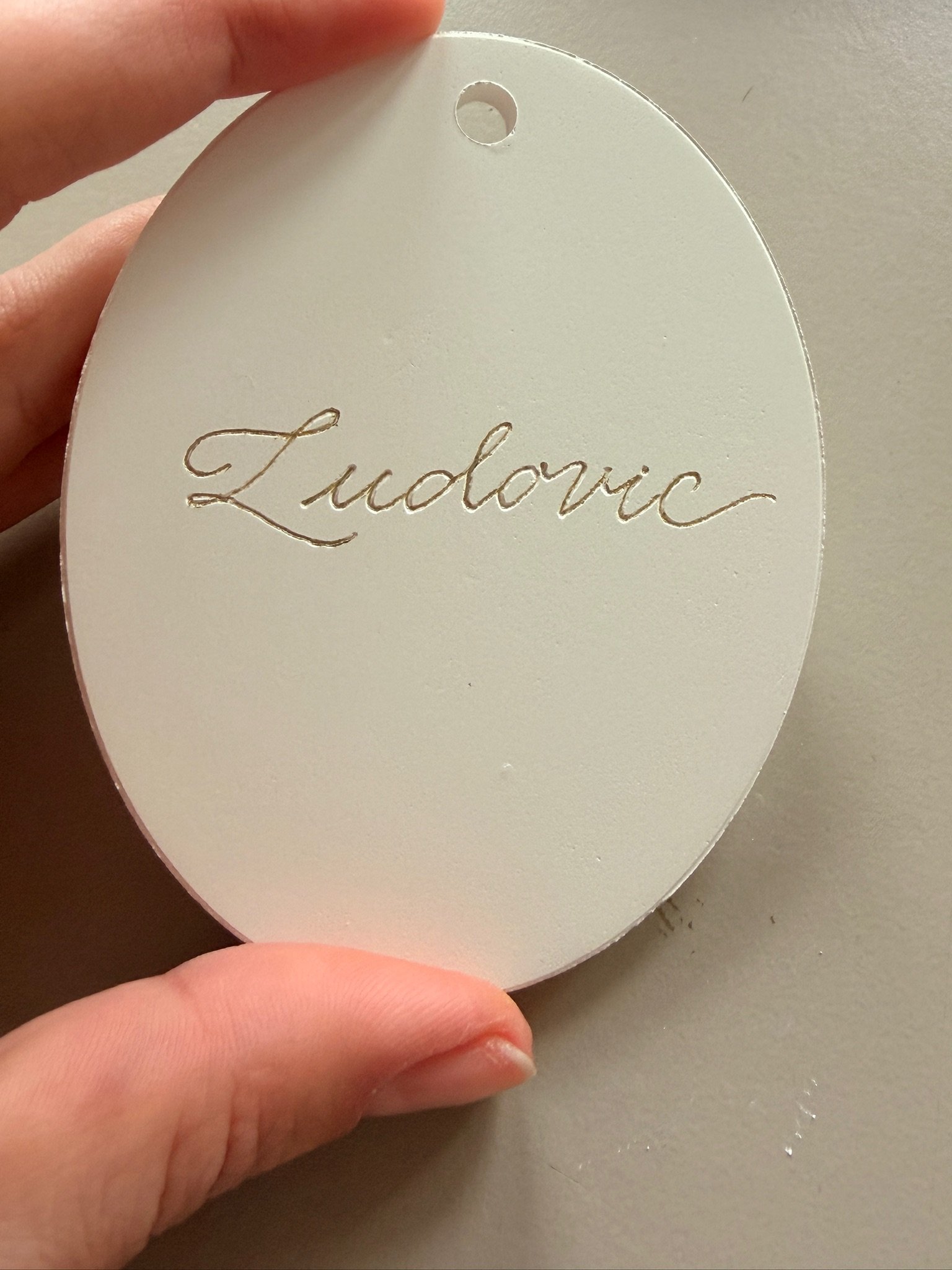 Calligrapher  personalising Dior biscuit medallion with Client's name.