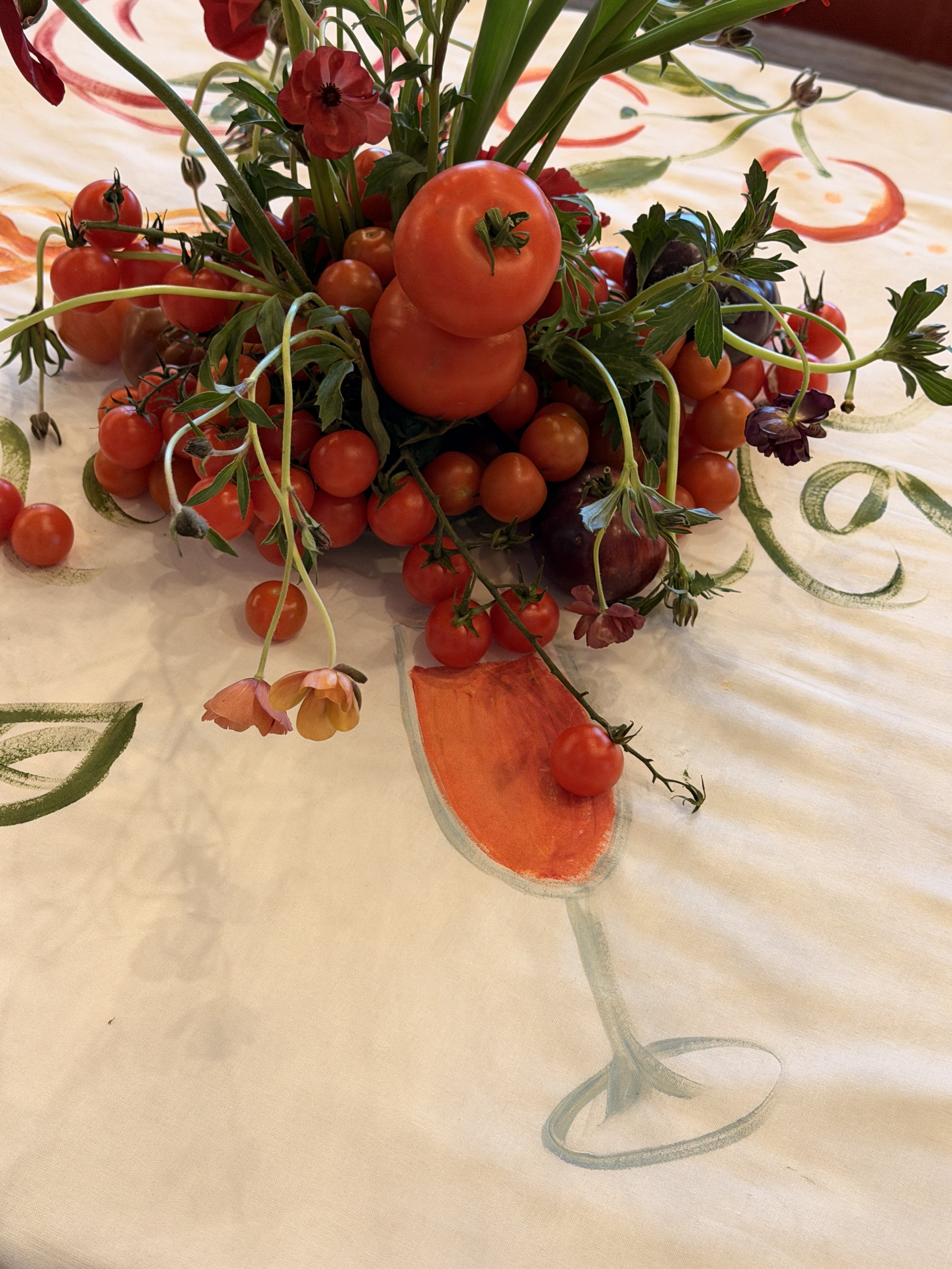 Detail of a hand-painted tablecloth beneath the place settings at a brand dinne