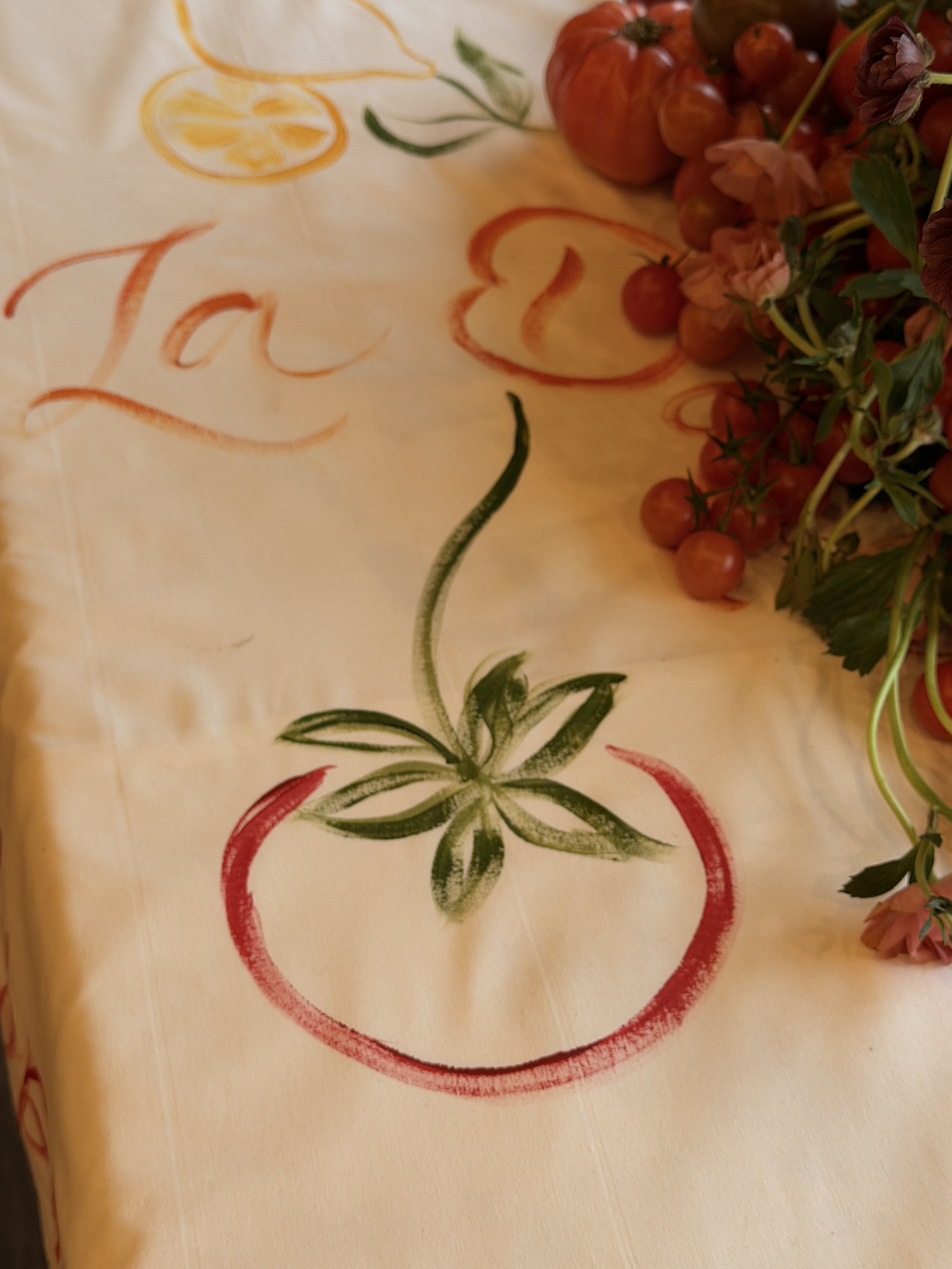 Hand-painting decorative details onto tablecloths for a TikTok brand event in the UK