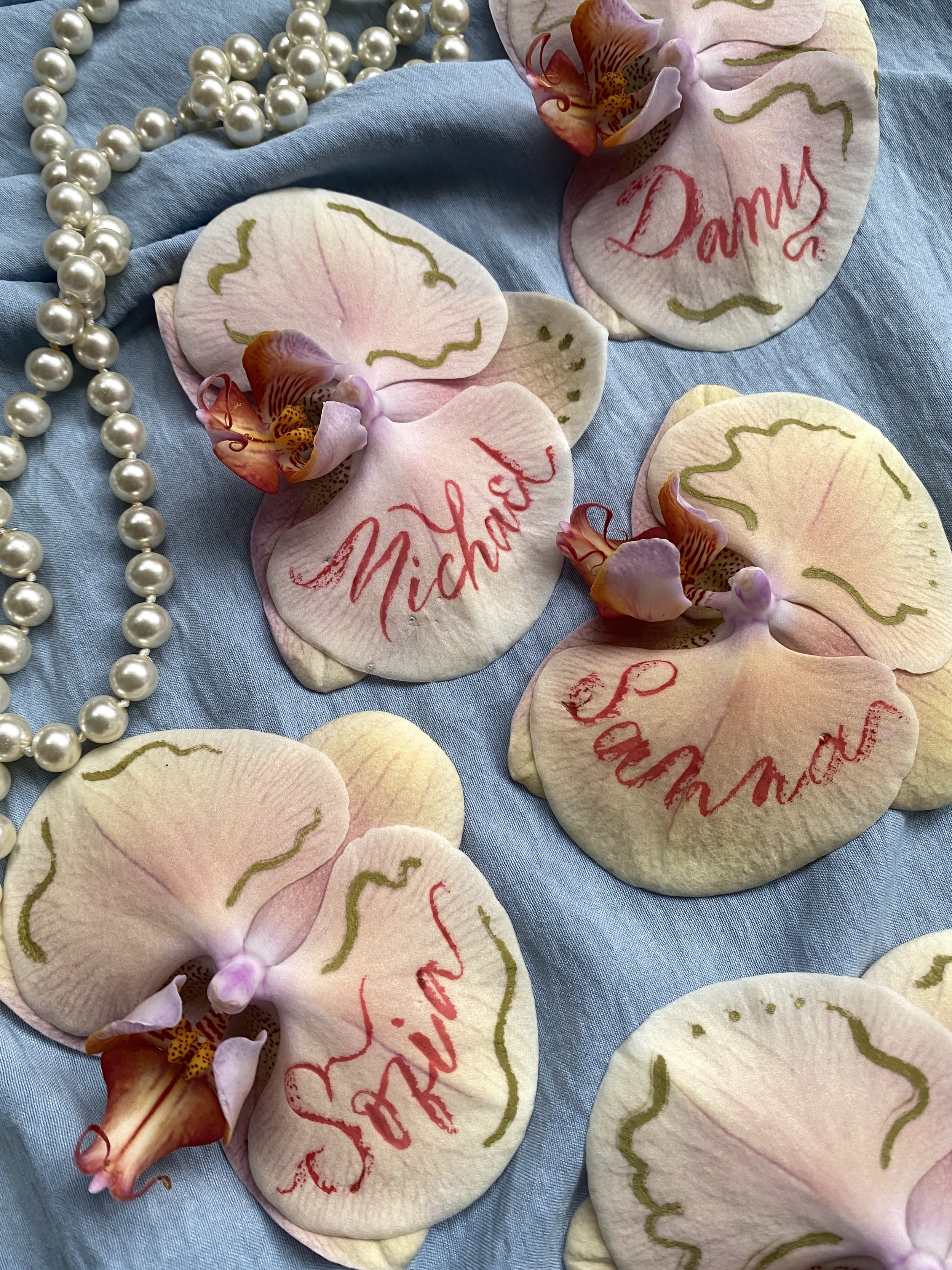 Pale pink and yellow anthurium flowers personalised with names in red calligraphy