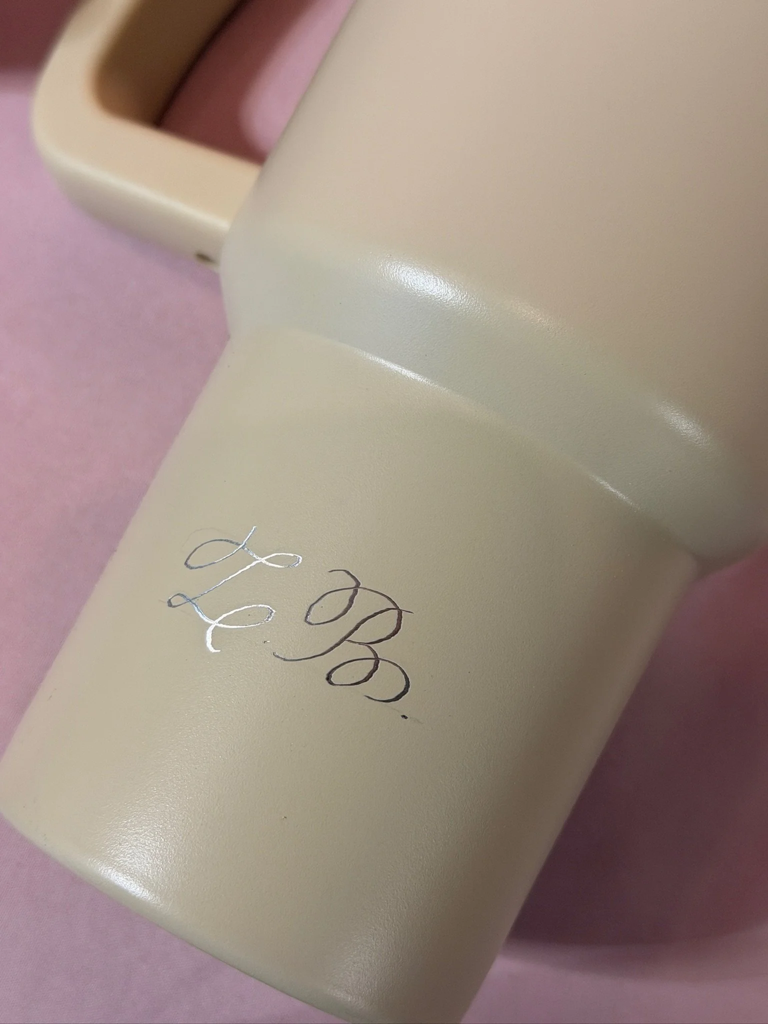 Close-up of a pale bottle personalised with an engraved script monogram