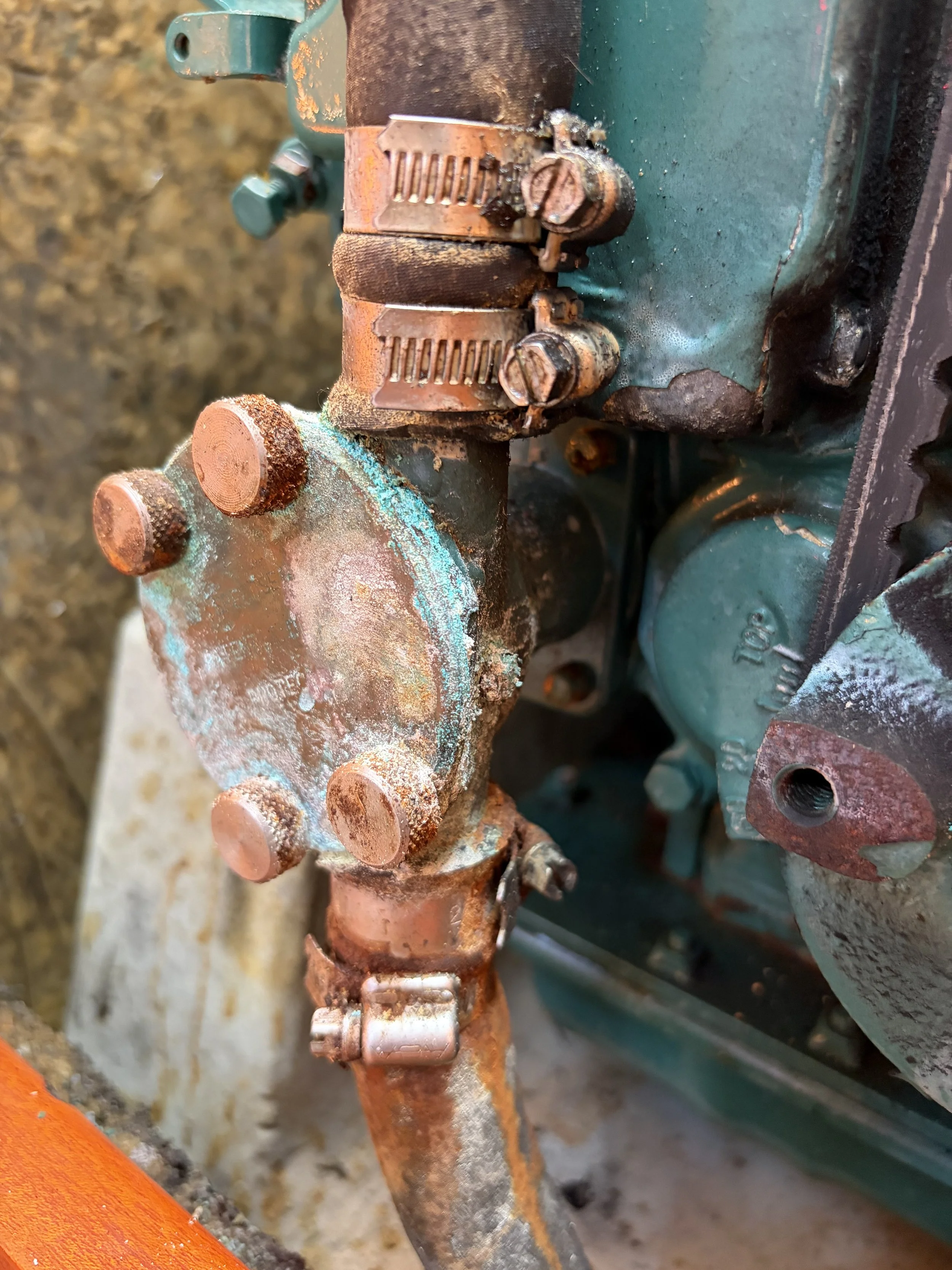 Close-up of rusted mechanical parts and bolts, possibly on an old engine or machinery, with some corrosion and dirt visible.