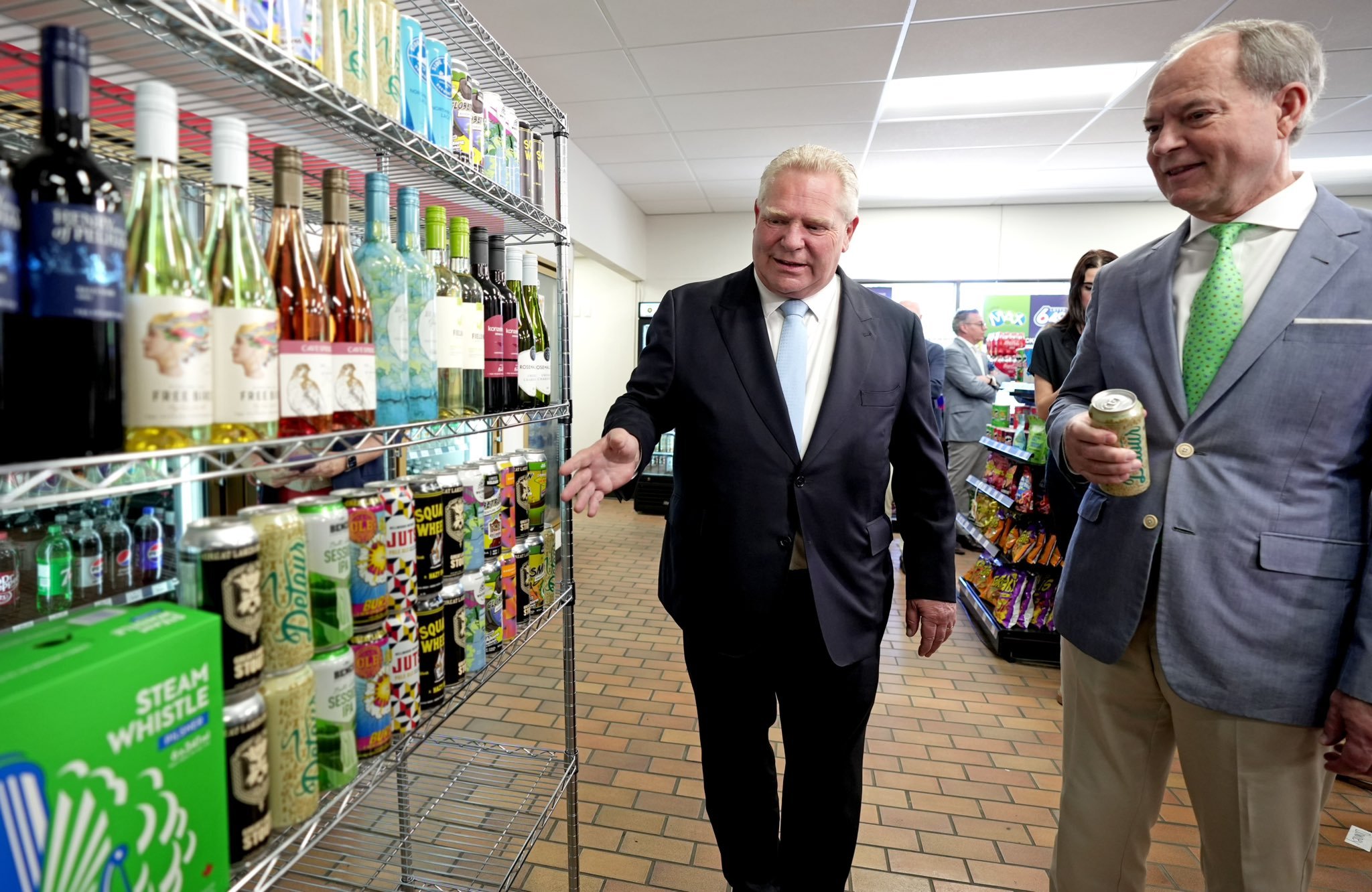 Premier Doug Ford and Minister of Finance Peter Bethlenfalvy looking at shelves stocked with craft beer in a convenience store.