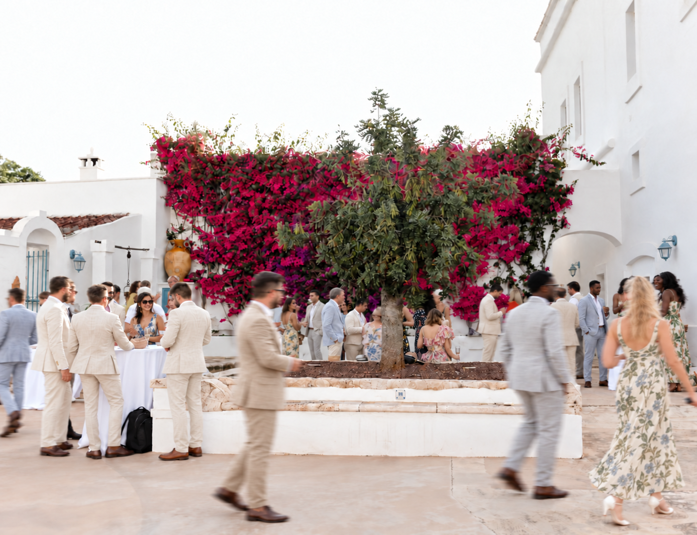 Linen-clad guests in a bougainvillea courtyard.png