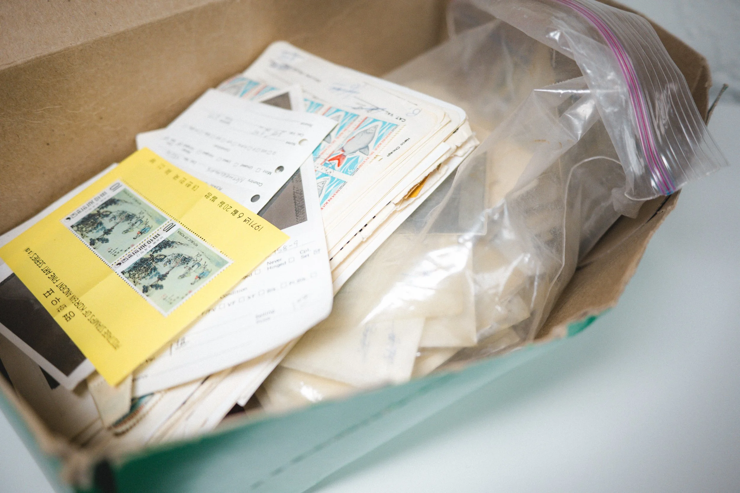 A cardboard box containing collectible tickets, a plastic bag, and various paper items.