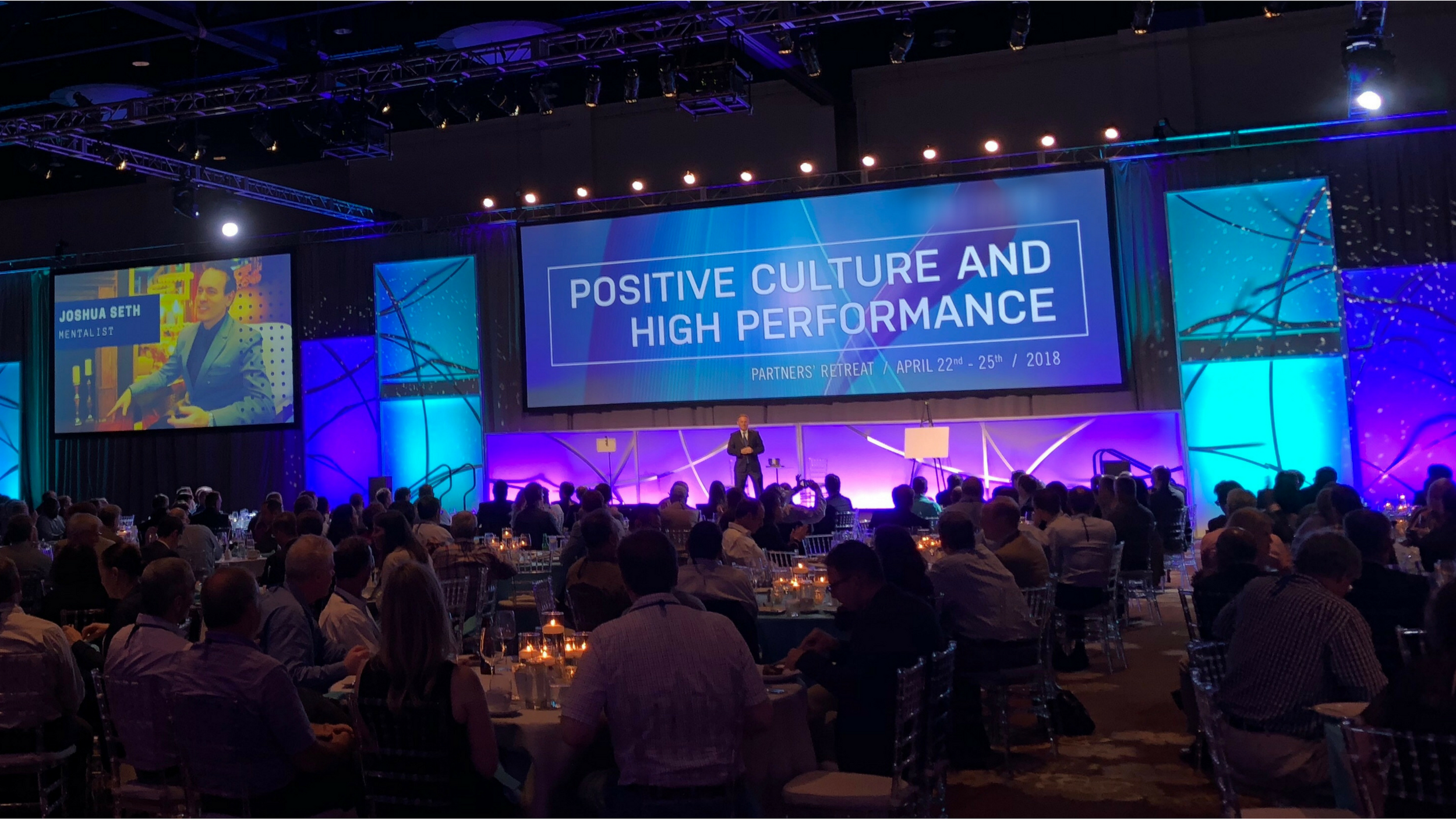 Joshua Seth delivering his workplace culture keynote to a large conference audience, inspiring teams to connect and unlock their potential.