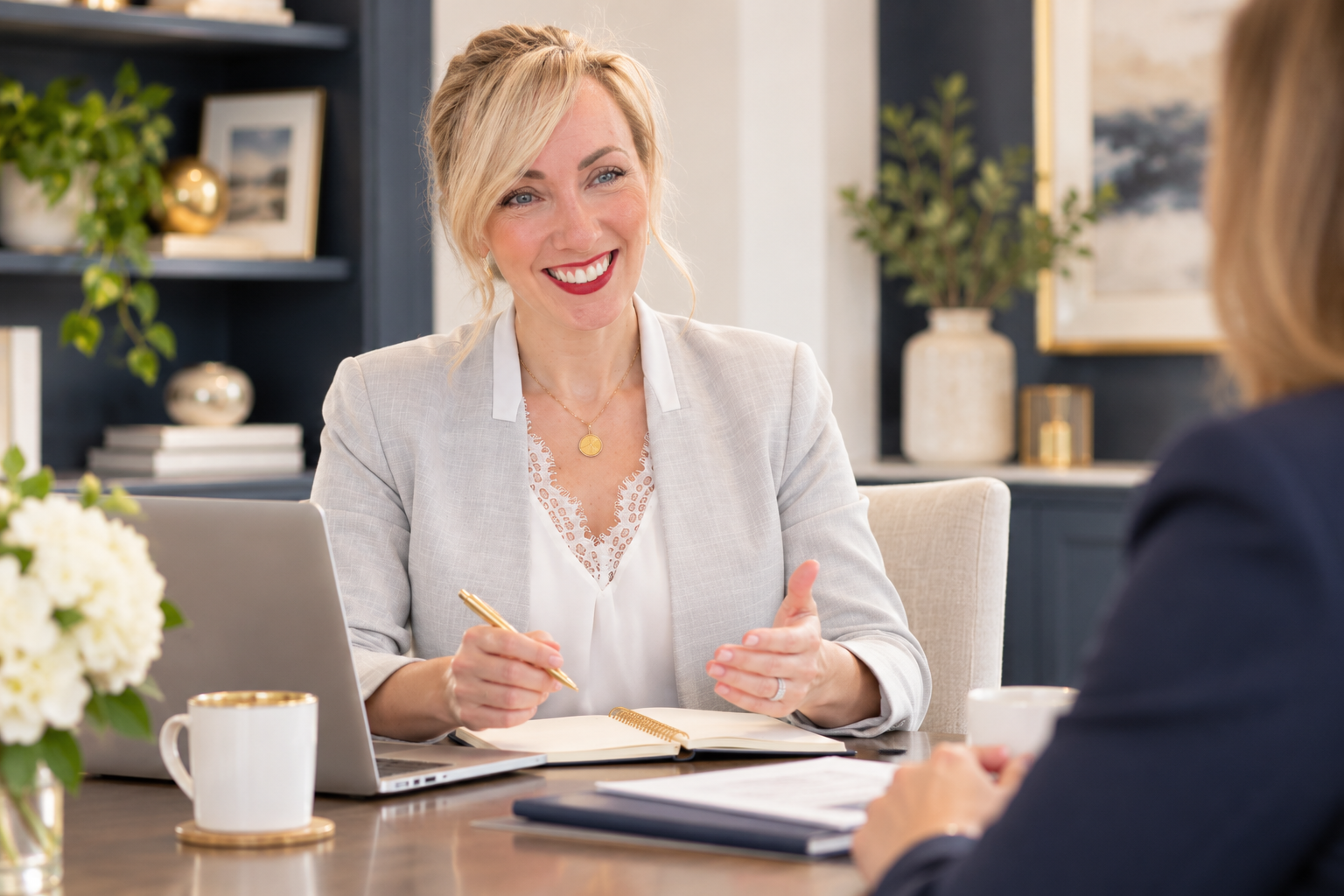 Amanda Stewart smiling and speaking with a client across a desk in her workspace