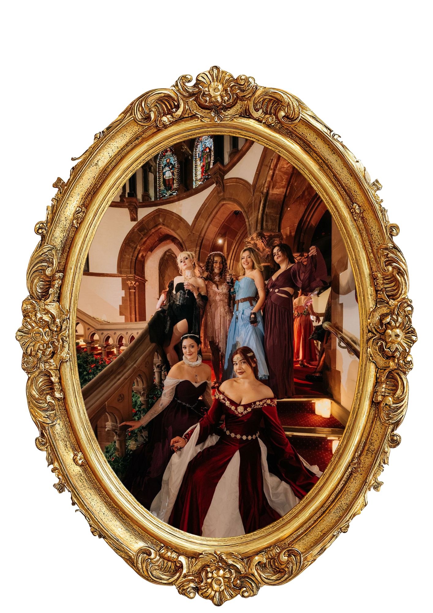 A group of women in historical costumes posing on a staircase inside a church, seen through an ornate gold-framed mirror.