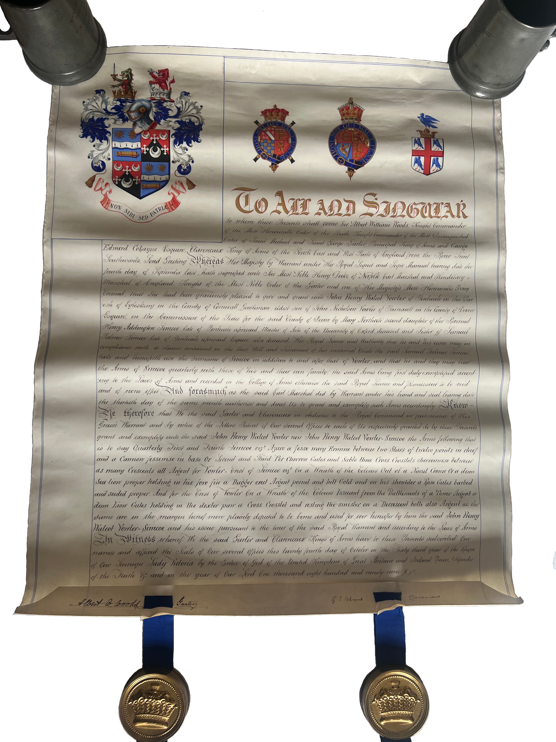 An ornate historical document or proclamation with a coat of arms at the top, flanked by various heraldic insignias, and decorated with golden seals at the bottom. The document is handwritten in a decorative script, detailing a royal or noble proclamation or grant.