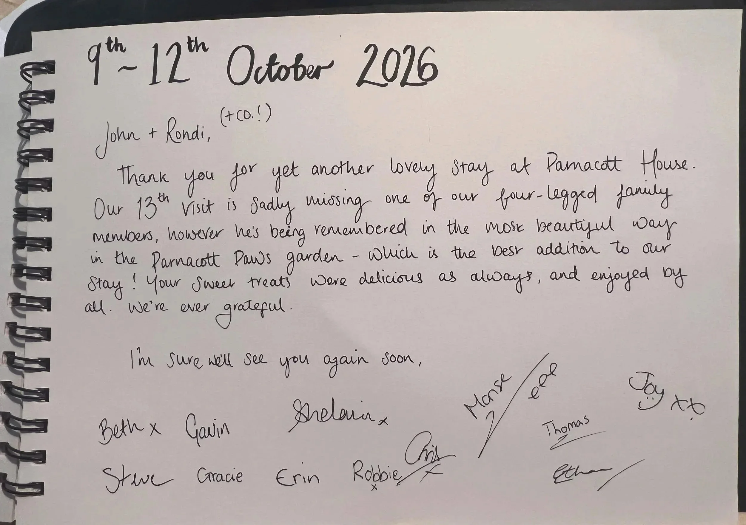 A handwritten note on a white sheet of paper with spiral binding on the left side, dating from October 1st to October 12th, 2016. The note expresses gratitude for a stay at a place called Parncott House, mentioning the missed family members and saying goodbye. The note is signed by various names.