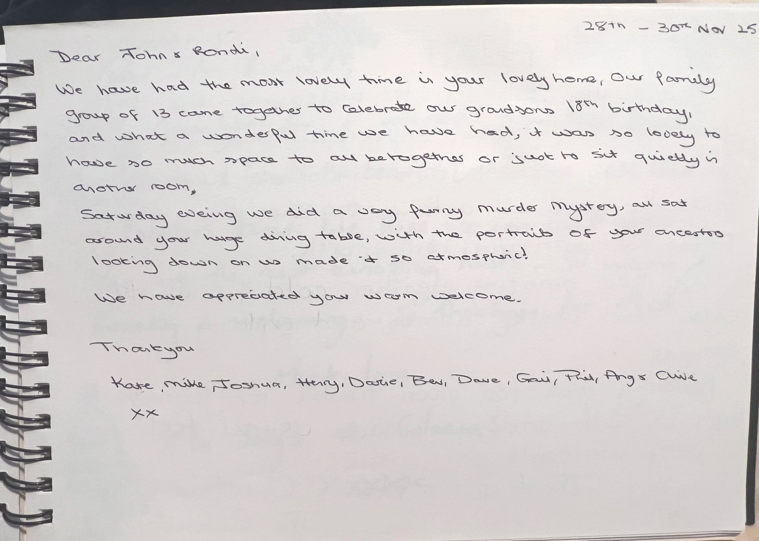 A handwritten letter on a spiral-bound notebook page dated 28th - 30th Nov 25, expressing gratitude and recalling a family celebration and an evening with a murder mystery game. The letter is addressed to John and Randi and signed by Kate, Mike, Joshua, Terry, Darie, Ben, Dave, Craig, Trish, Angie, and Chloe.