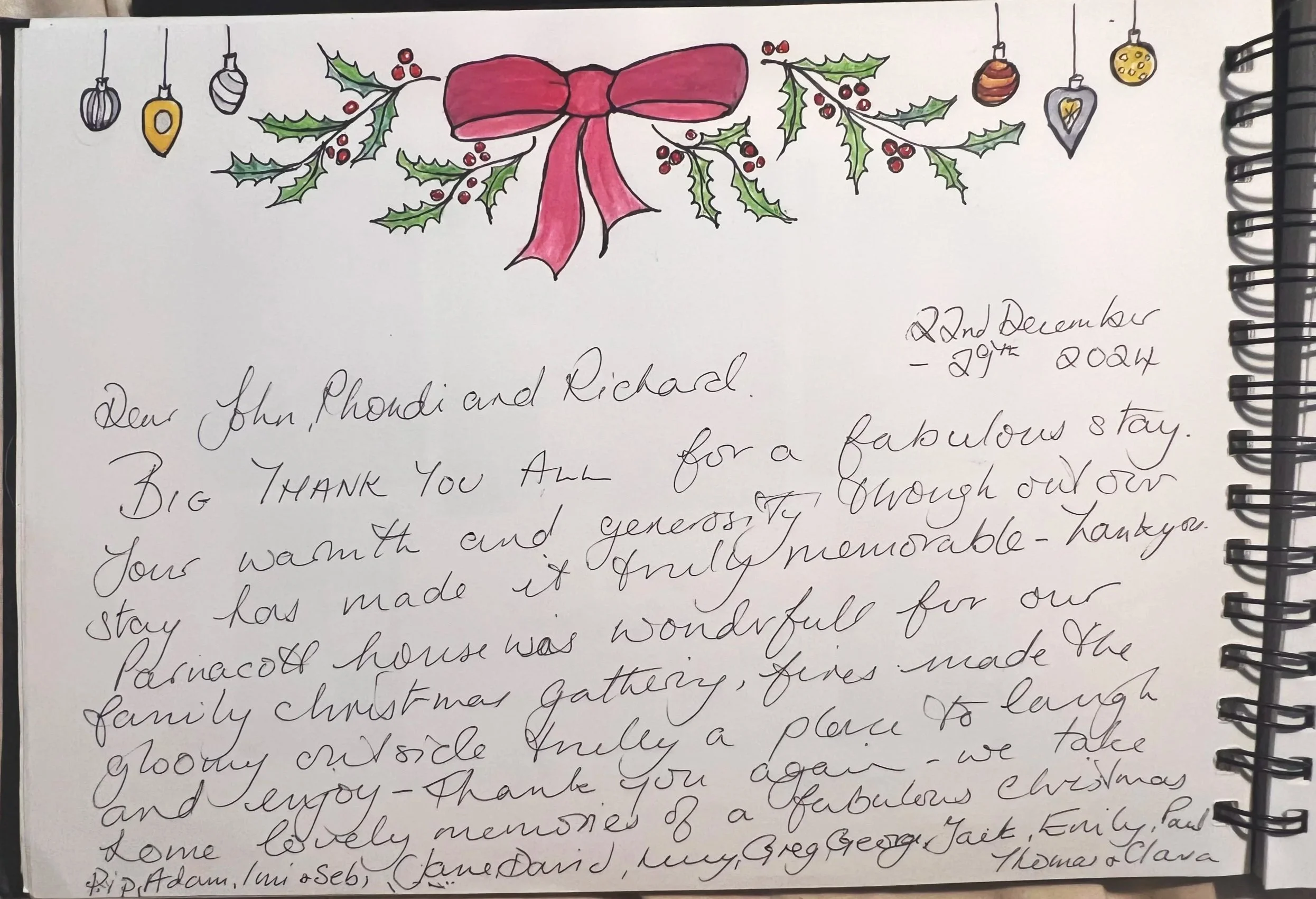 A handwritten letter with a decorative illustration of holly leaves, red berries, and Christmas ornaments at the top. The letter is addressed to John, Rhonda, and Richard, thanking them for a memorable stay and describing a Christmas gathering at a family house.