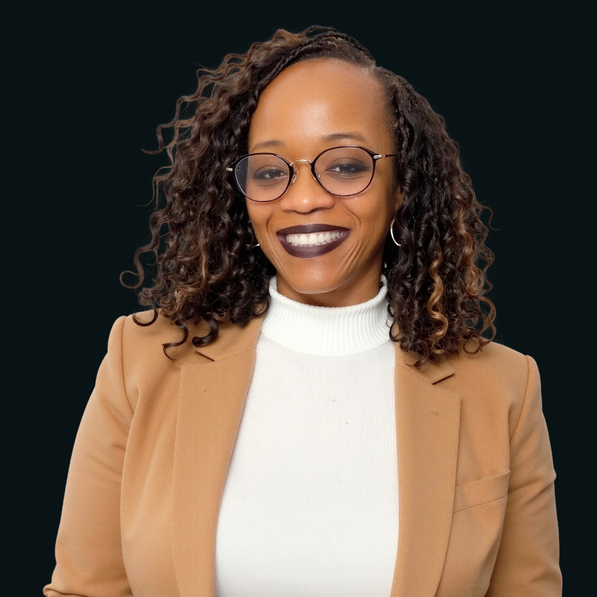 Close-up of a smiling African American woman with curly hair, glasses, and wearing a beige blazer and white turtleneck, against a dark background.