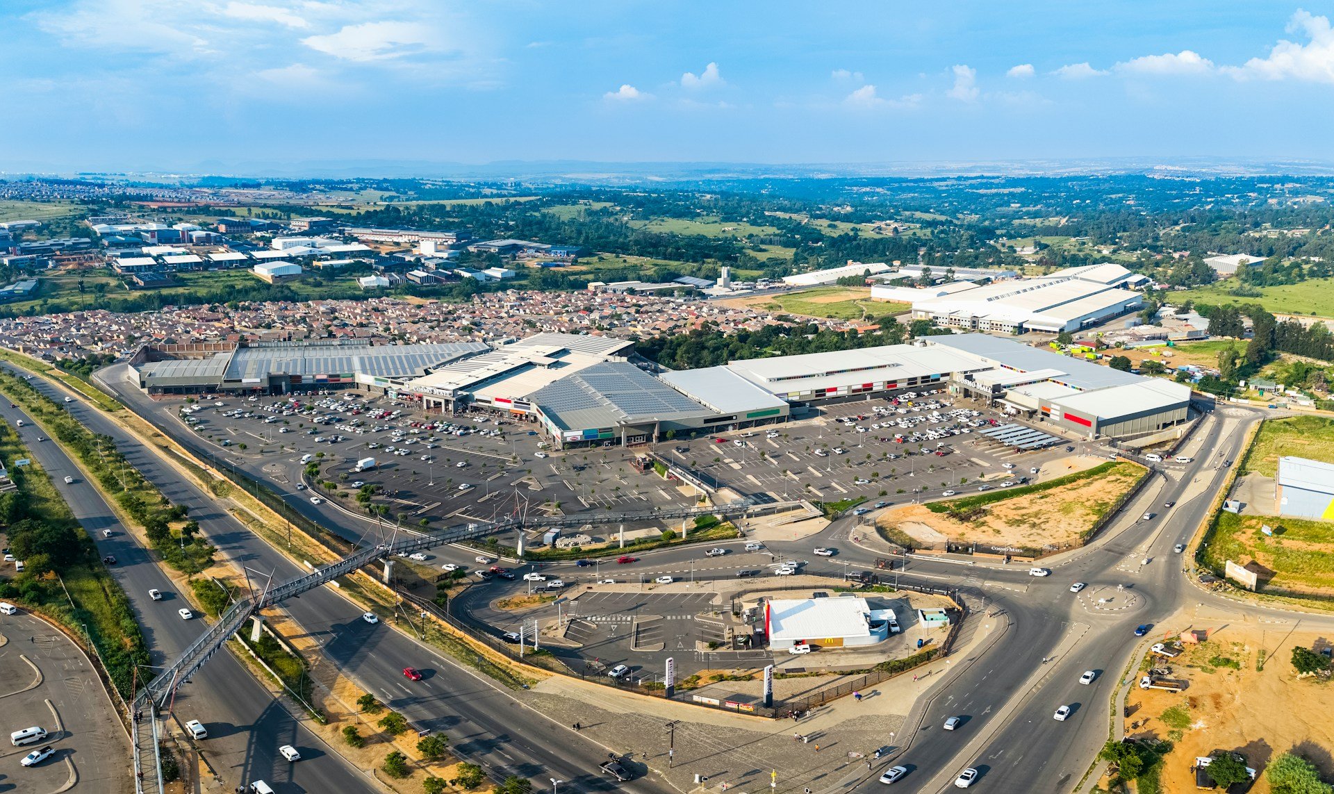 Aerial view of a large retail shopping center surrounded by roads and parking