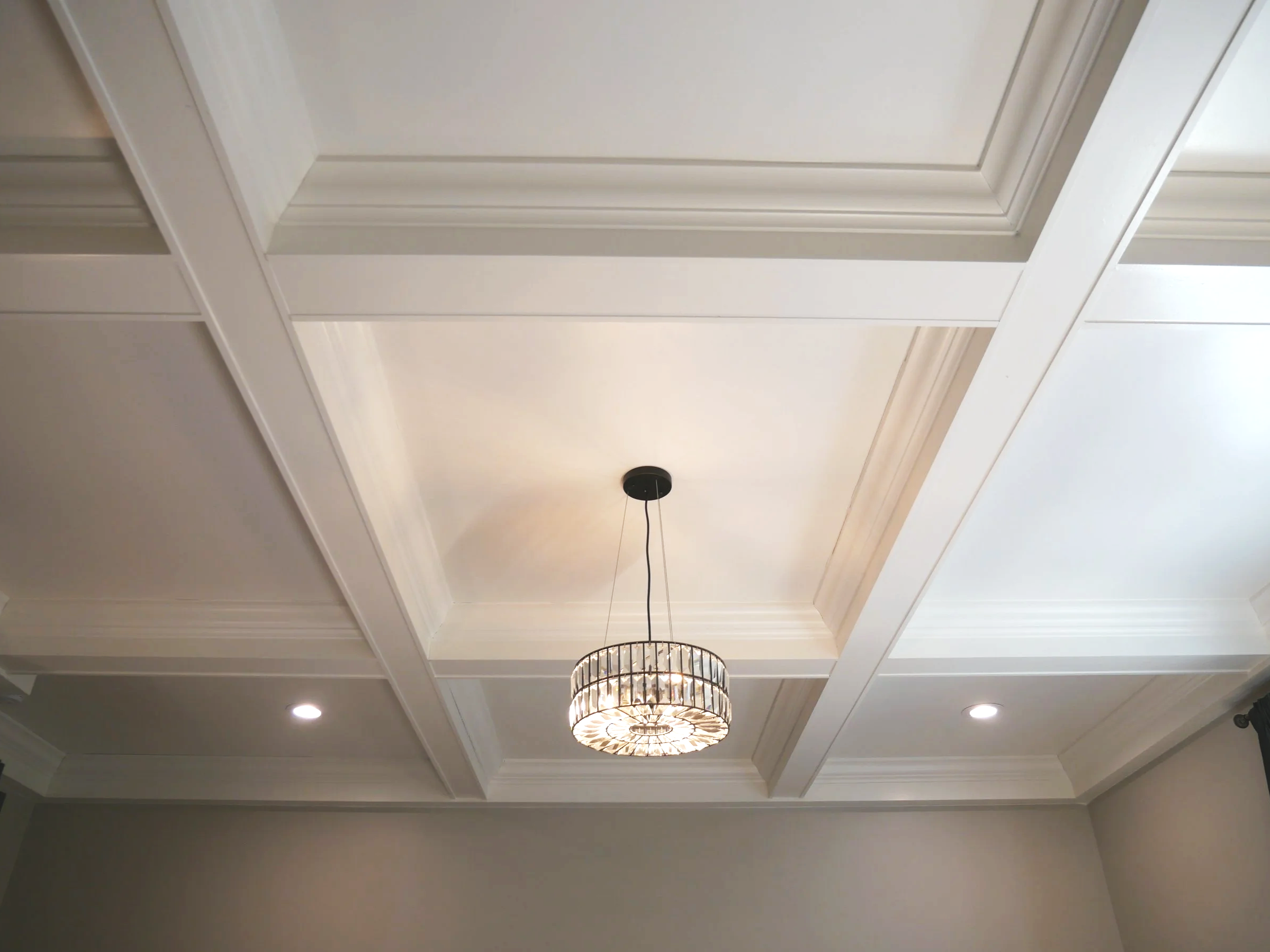 Ceiling with recessed lighting, a decorative chandelier, and crown molding.