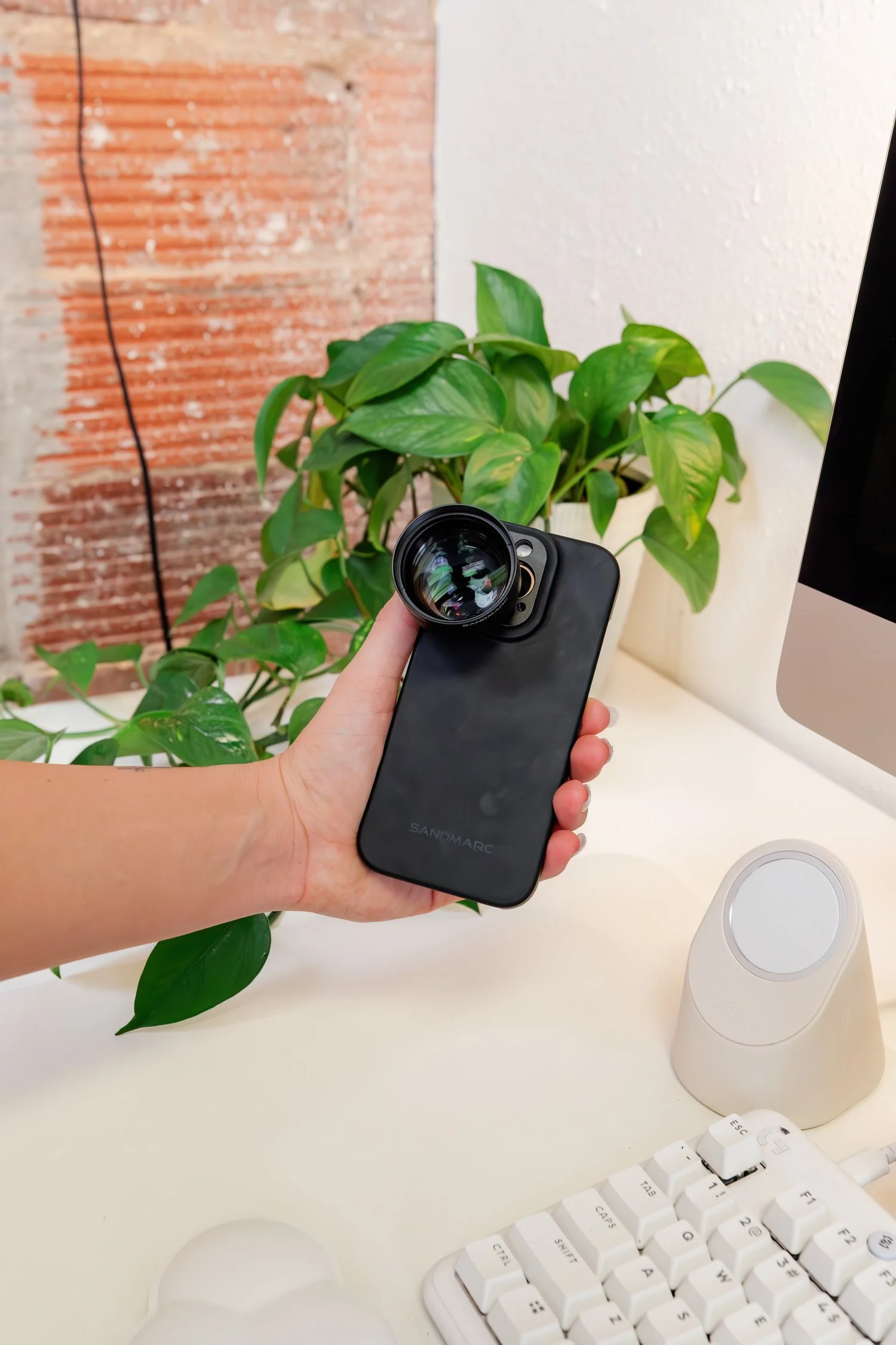 Phone lens product photograph in a bright workspace.