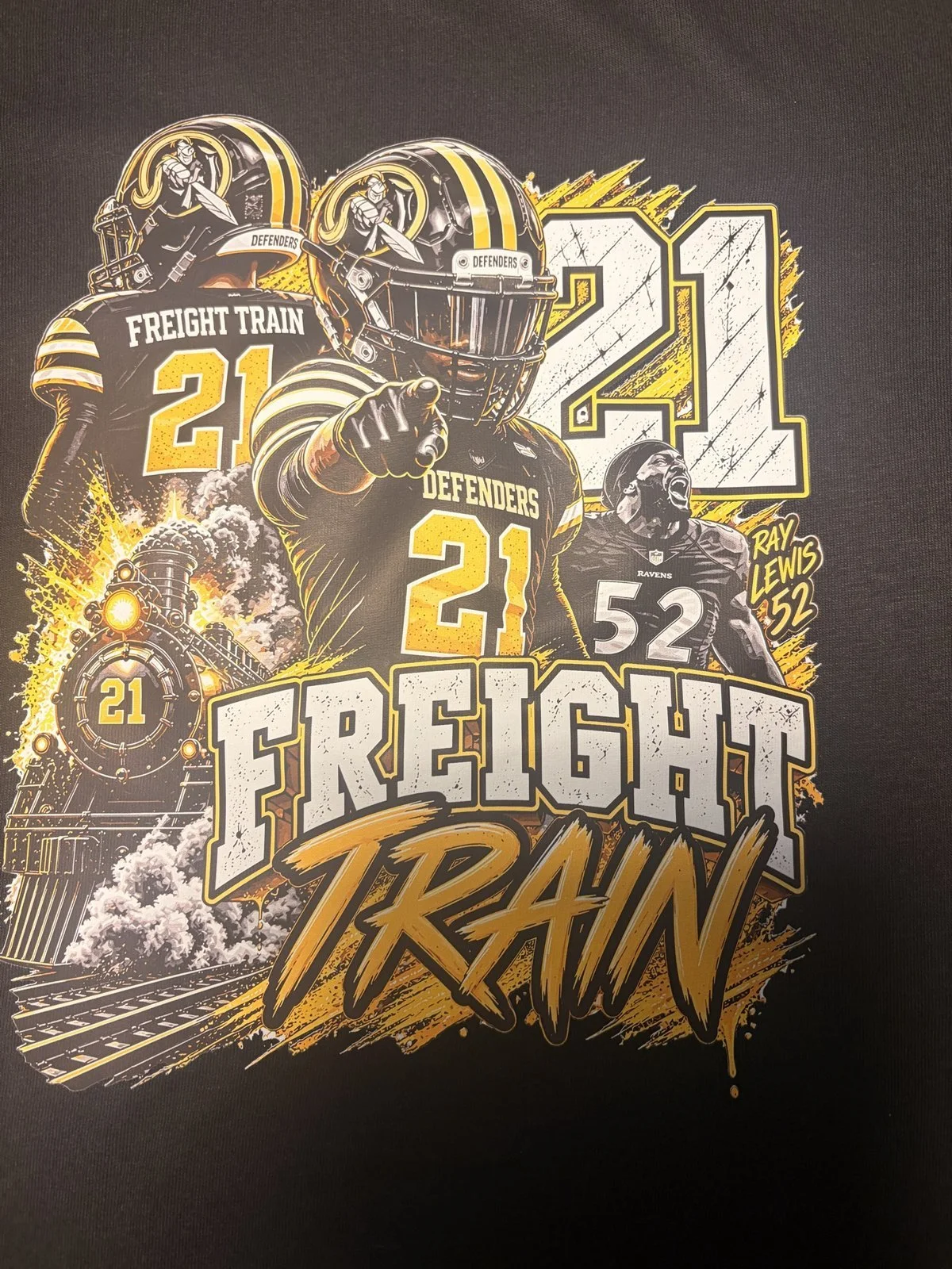 Black shirt printed with a Defenders player number 21 Freight Train collage design in gold and white
